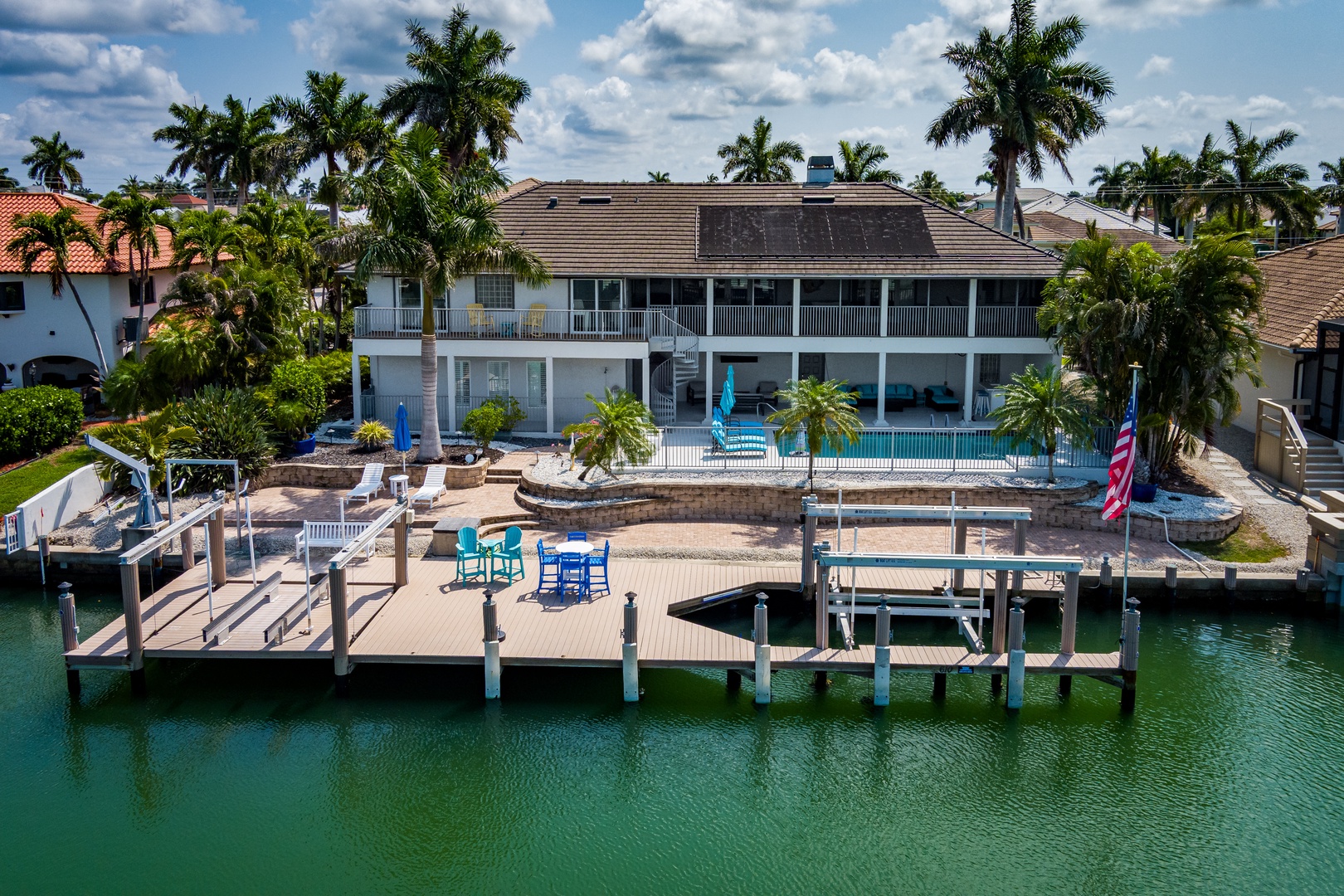 Waterfront estate in a tropical setting with private dock, pool, and lush palm-lined surroundings perfect for a Florida getaway.