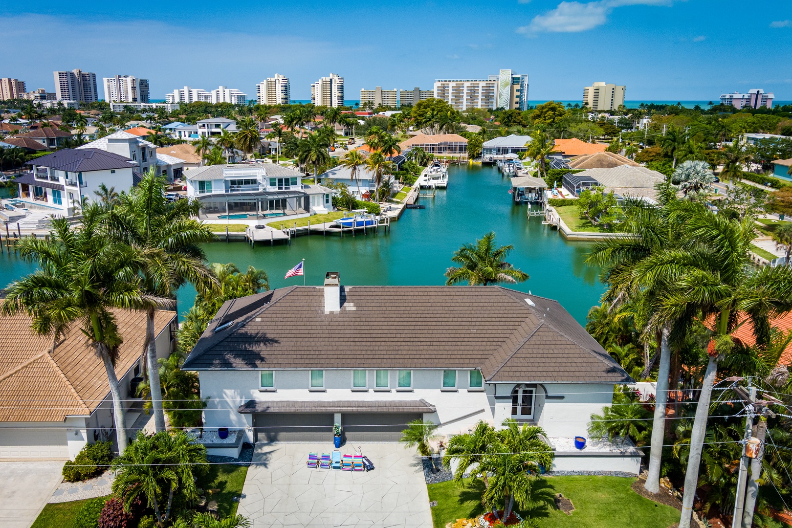 Waterfront property situated along a picturesque canal in a vibrant coastal community with direct access to turquoise waters and nearby high-rise buildings.