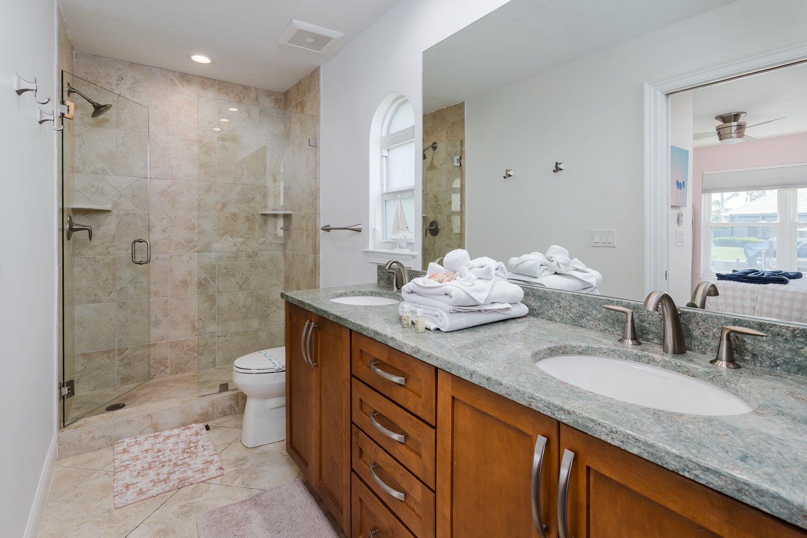 Unwind in your spa-like bathroom featuring a spacious walk-in shower, elegant granite counters, and plush towels awaiting your arrival.