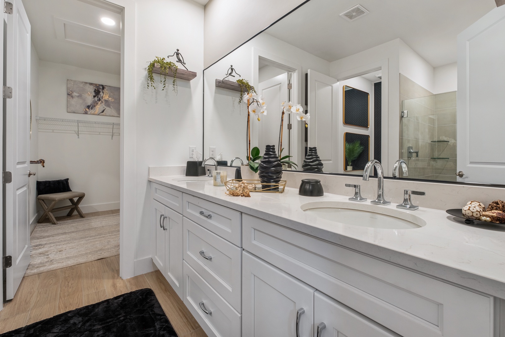 Your private spa-like bathroom features dual vanities with marble counters and elegant fixtures for your morning routine.