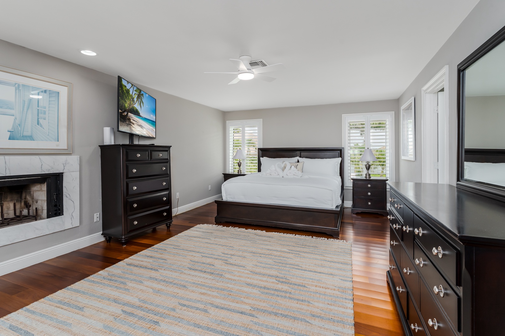 Unwind in your elegant primary suite, complete with a cozy fireplace, smart TV, and rich hardwood floors that invite ultimate relaxation.