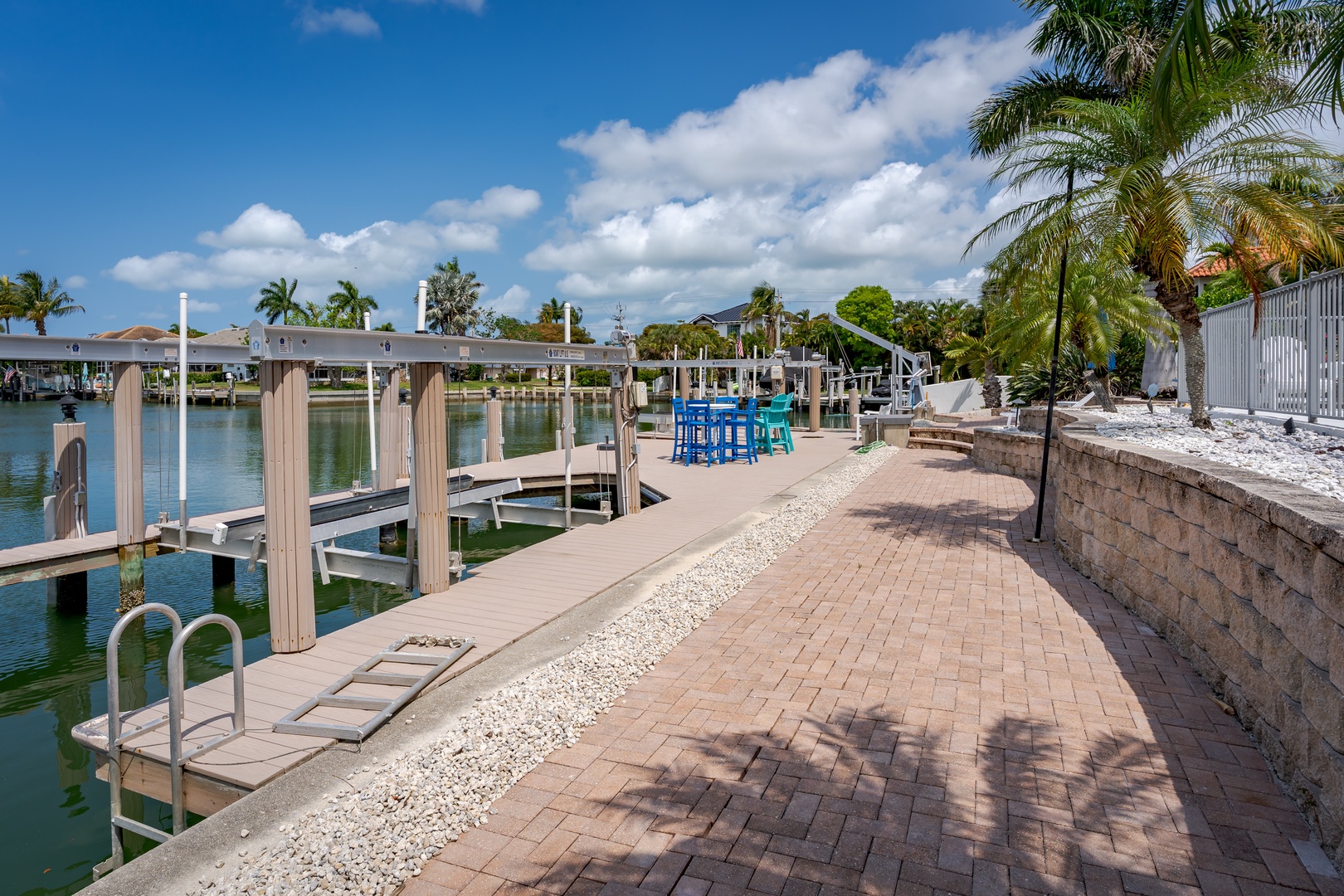 Private waterfront dock with direct canal access, palm-shaded seating, and serene views perfect for boating enthusiasts and sunset watchers.