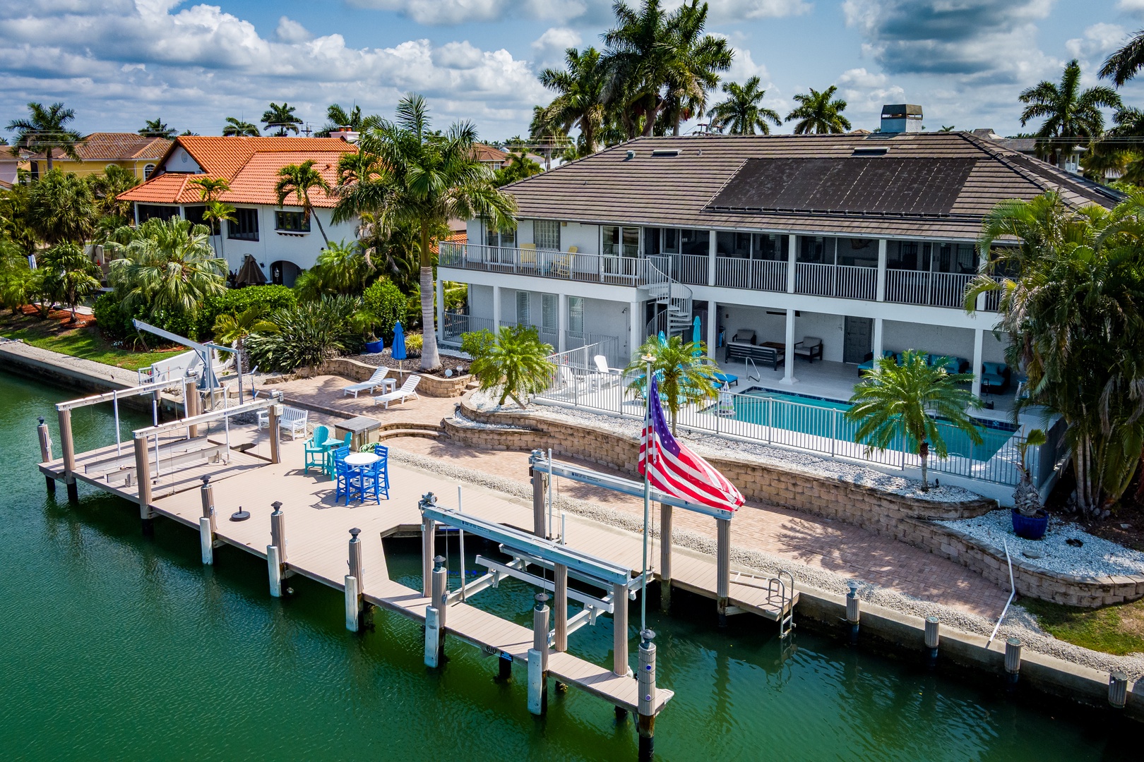 Waterfront property with private dock, swimming pool, and tropical landscaping in a serene residential neighborhood with canal access.