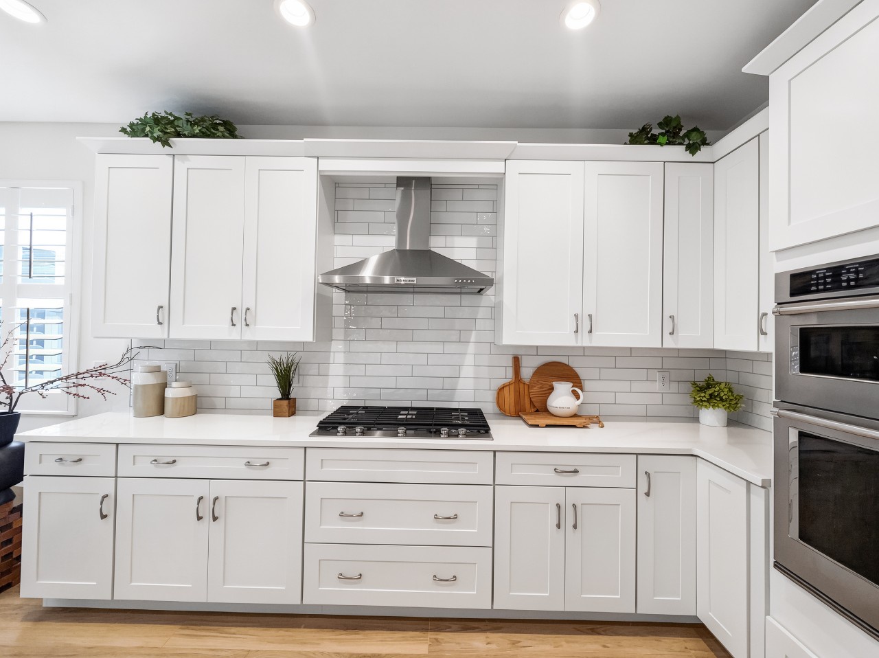 Step into your bright, modern kitchen where crisp white cabinets and subway tiles create a clean canvas for your culinary adventures. The gas range and stainless hood await your favorite recipes.