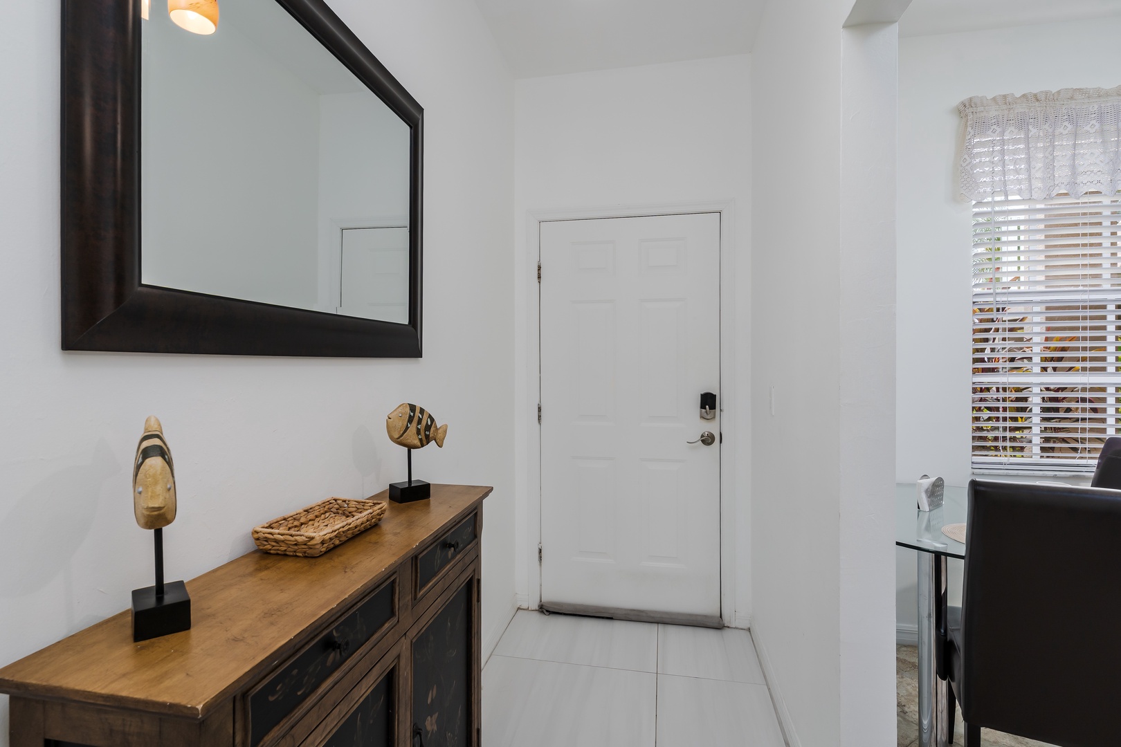 Your arrival is met with bright, minimalist style—clean white tile leads you past thoughtful touches like warm wood and artful décor that set a welcoming, sophisticated tone from the moment you step inside.