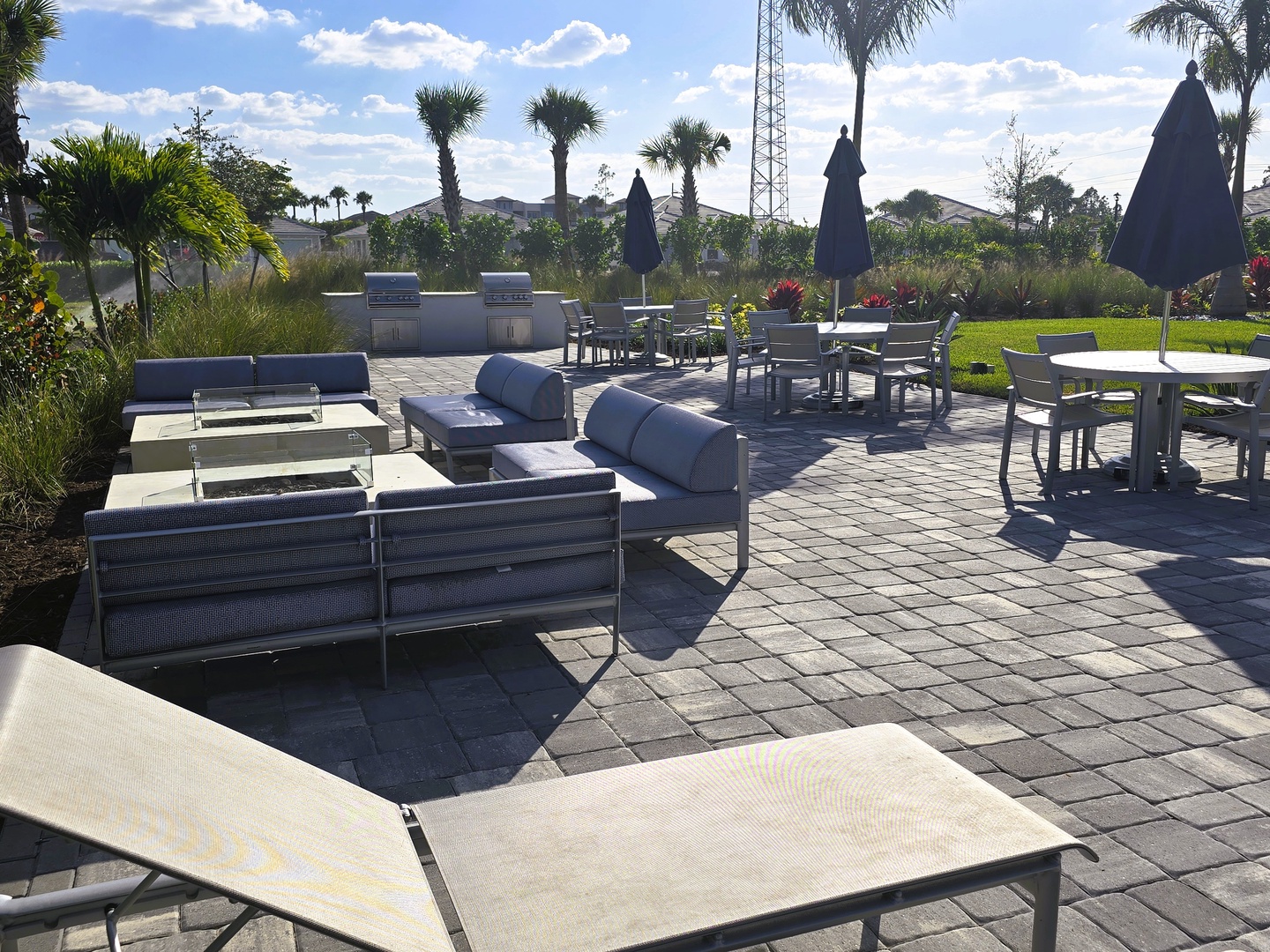 Relax on plush lounge chairs in this inviting outdoor oasis surrounded by swaying palms, open blue skies, and lush greenery. Your perfect spot to unwind after a day of exploring.