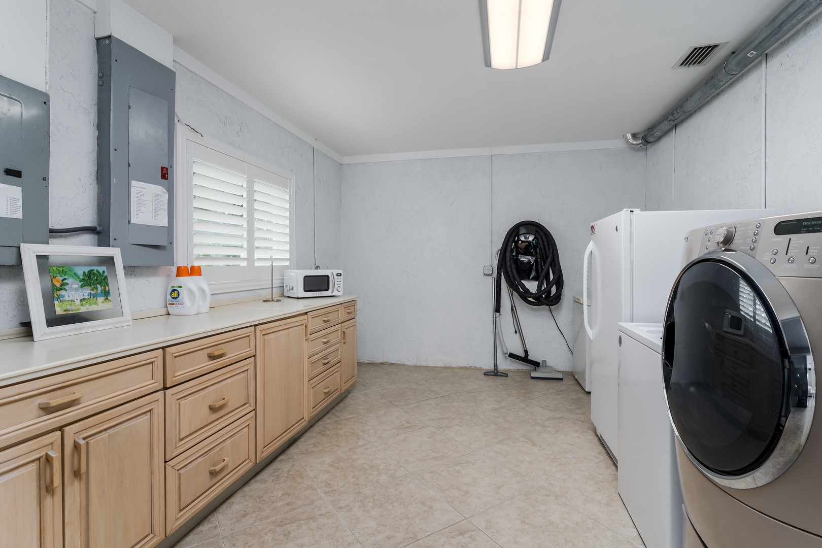 Spacious laundry room with full-size washer and dryer, plus ample counter and cabinet space for all your organizing needs during your stay.