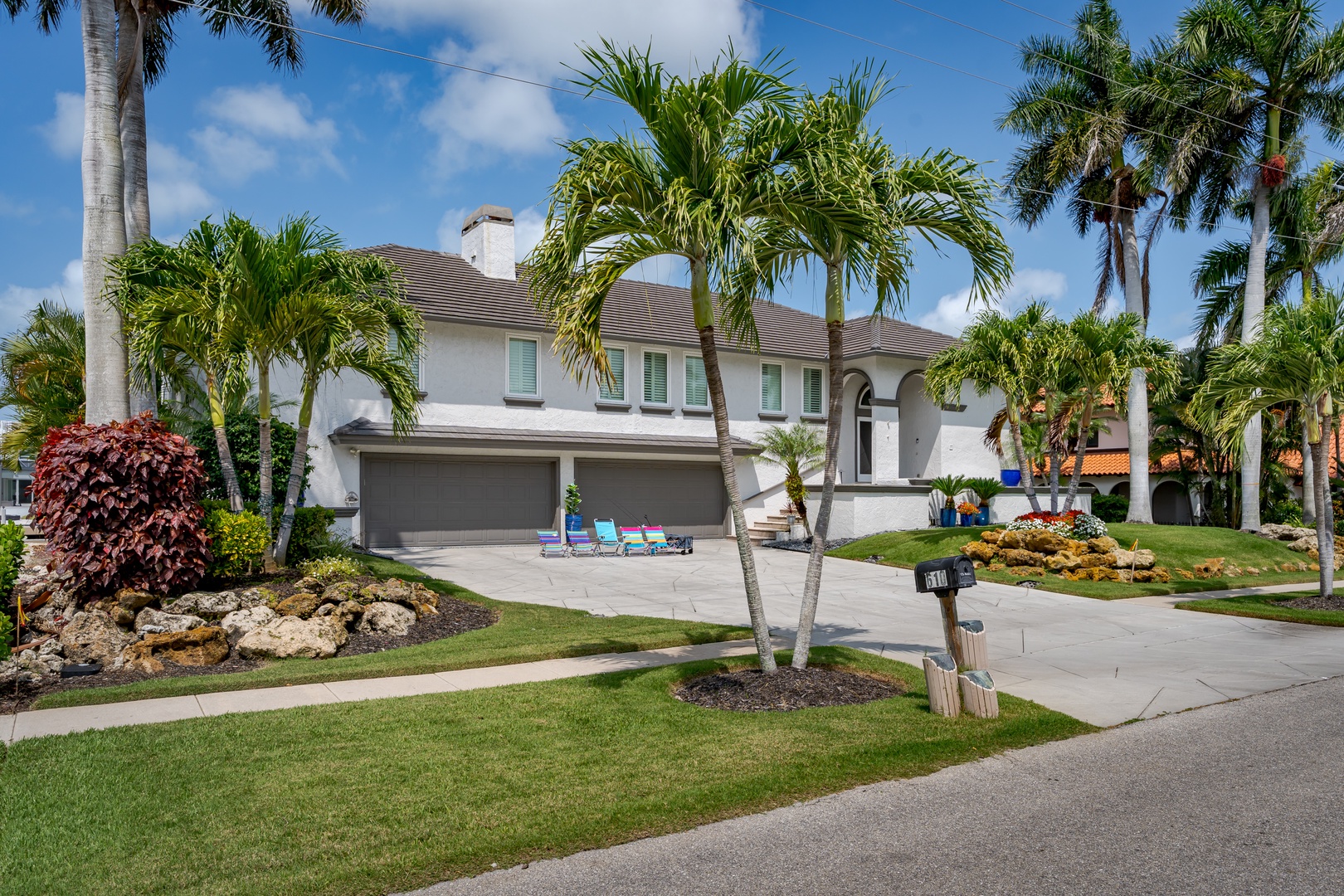 Elegant two-story home with tropical landscaping, lush palm trees, and pristine grounds—your Florida retreat awaits in this vibrant neighborhood.