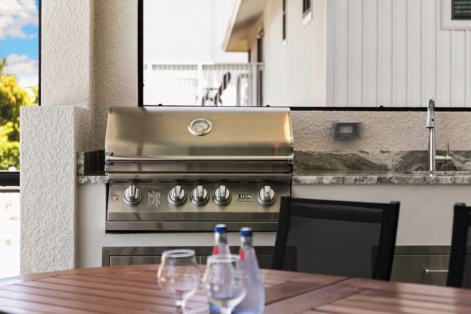 Your outdoor kitchen awaits with a premium stainless steel grill and sleek stone countertop—perfect for alfresco dining and sunset cocktails in style.