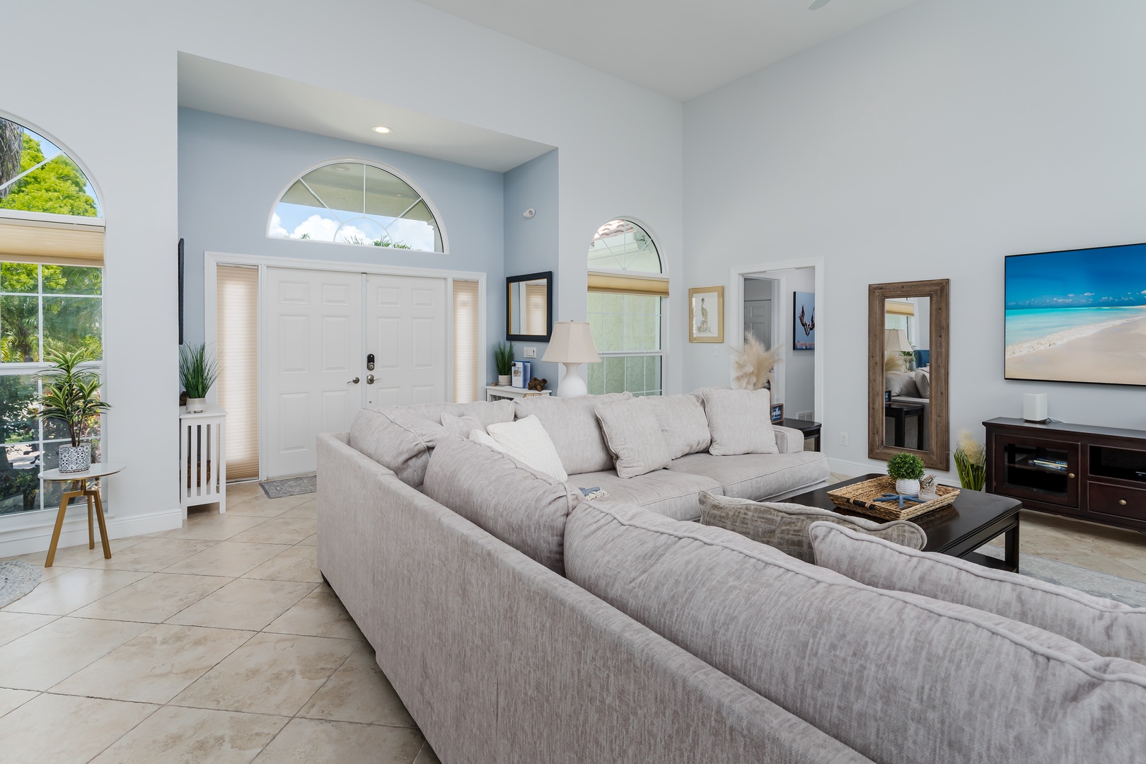 Sink into this plush sectional sofa where natural light streams through arched windows, creating your perfect spot for morning coffee or evening relaxation.