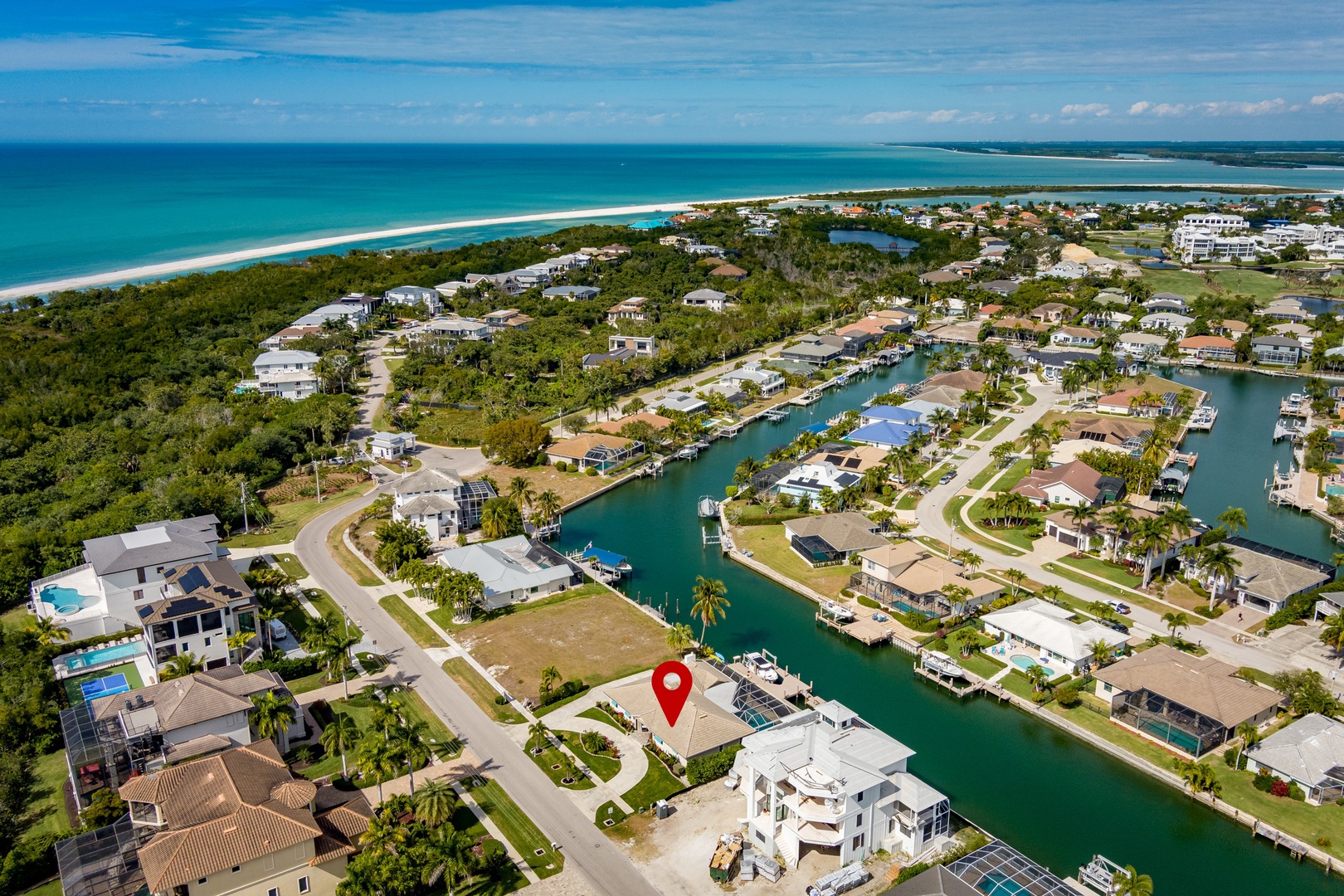 Stunning aerial perspective of the waterfront community where your vacation rental is located, showing pristine beaches and canal access nearby.
