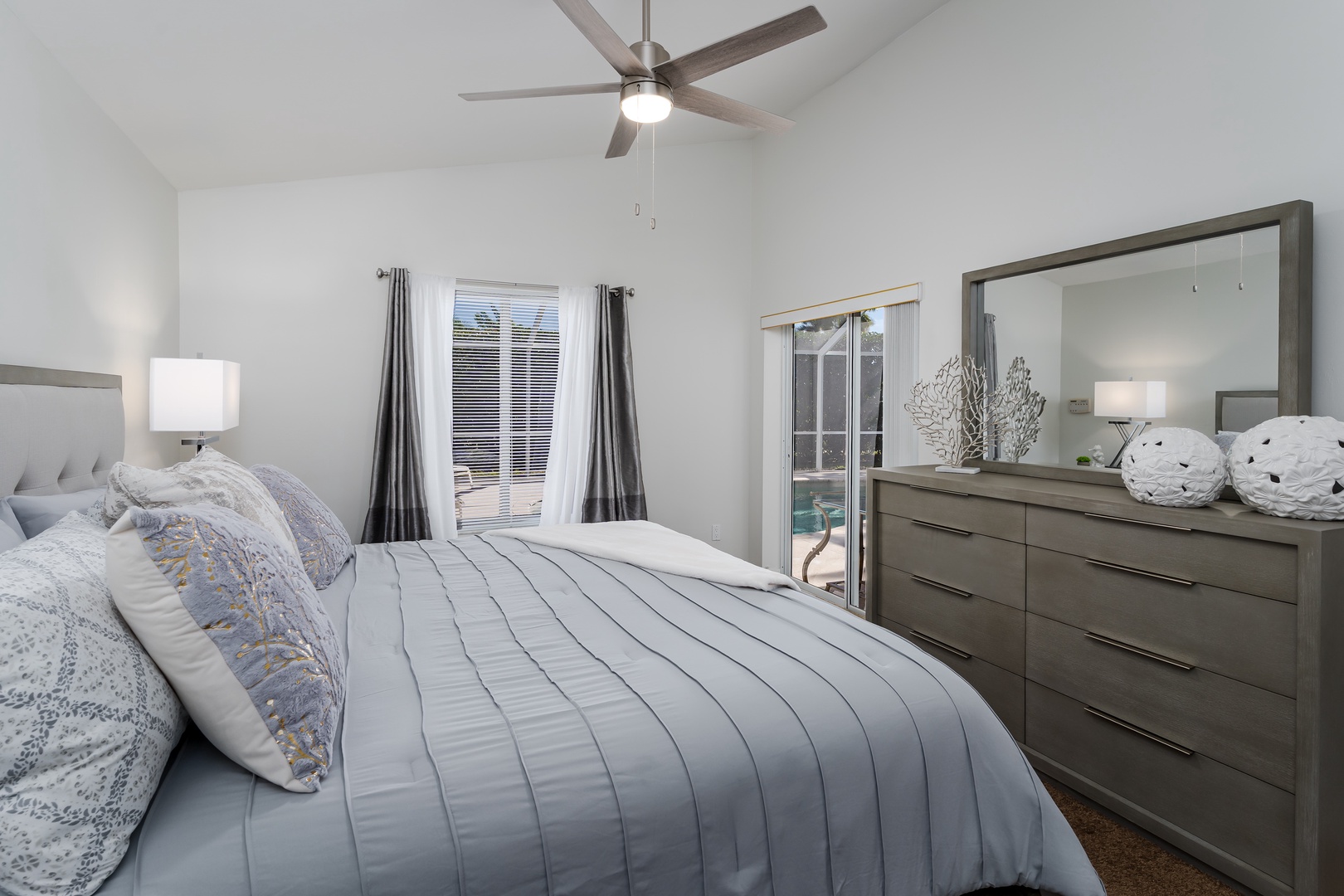 Sink into this dreamy bedroom where soft linens and gentle ceiling fan breezes create your perfect sleep sanctuary.