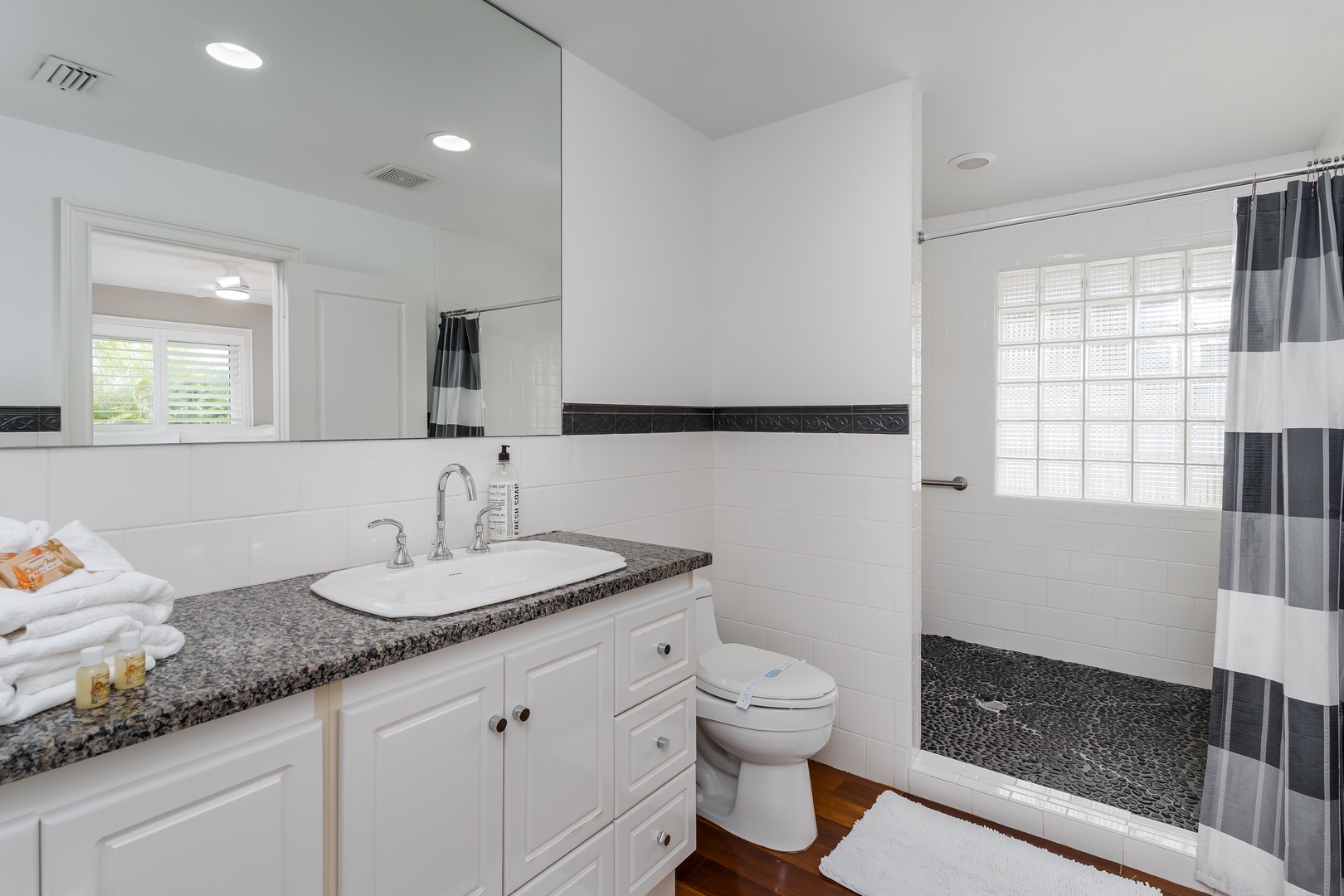 Freshen up in your bright, modern bathroom with sleek granite countertops, a spacious walk-in shower, and crisp white cabinetry. Fluffy towels await to wrap you in comfort.