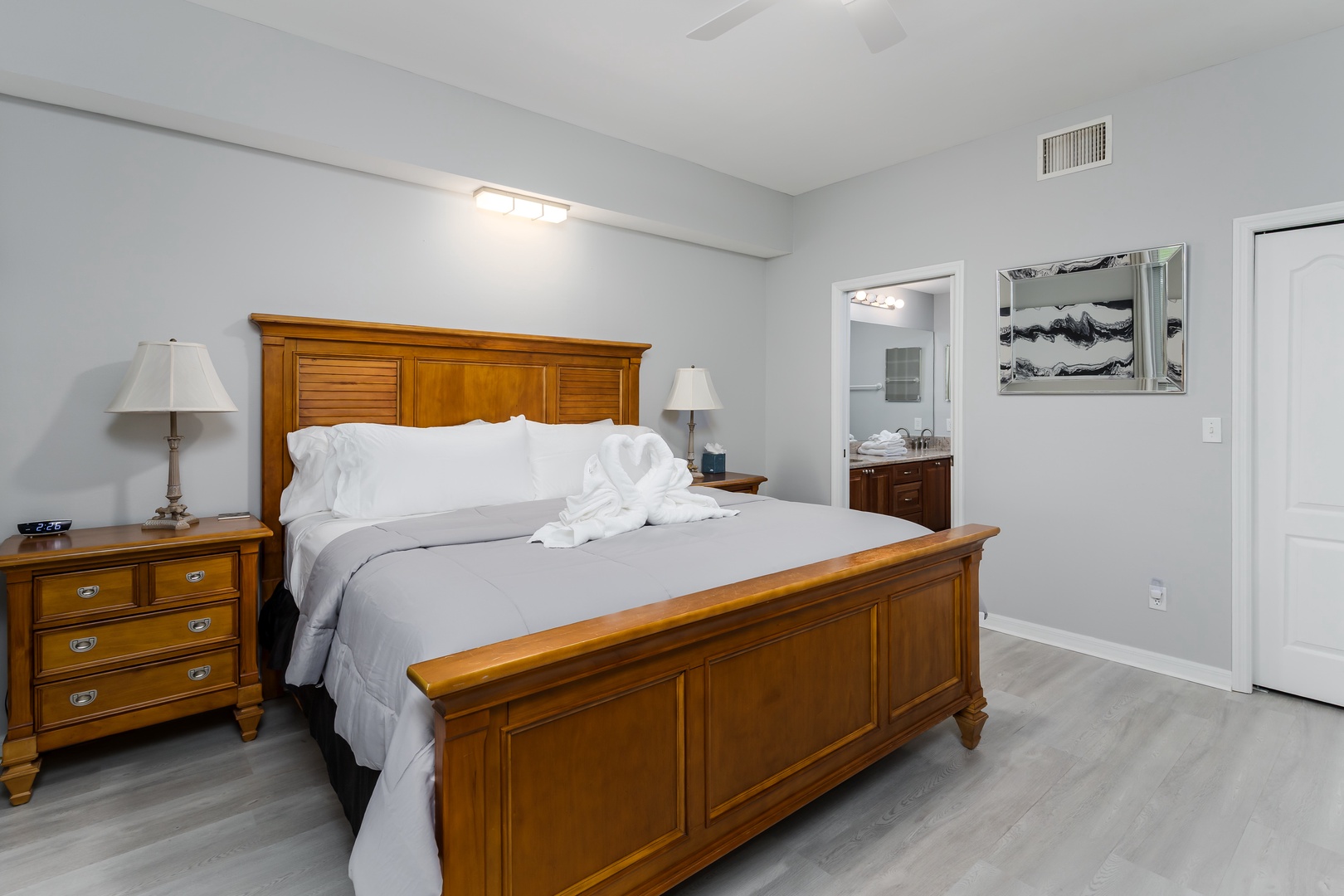 Step into your serene retreat, where soft gray tones and warm wood accents invite you to unwind. Crisp linens and a private en-suite promise restful nights in this thoughtfully designed bedroom.