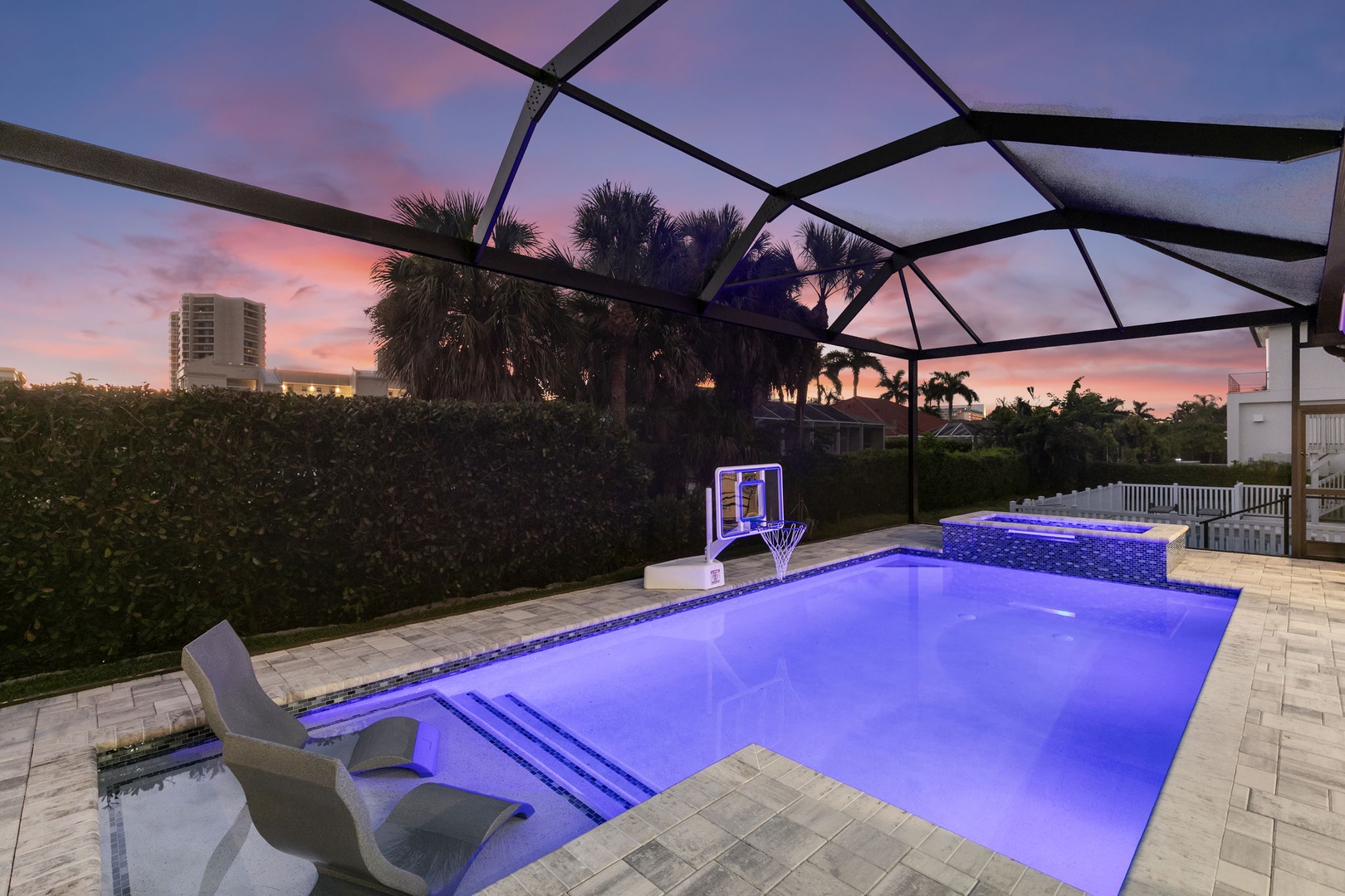 Dive into your private pool as the sky paints itself in shades of pink and purple. Illuminated water glows beneath a screened lanai, while palm trees sway in the warm evening breeze.