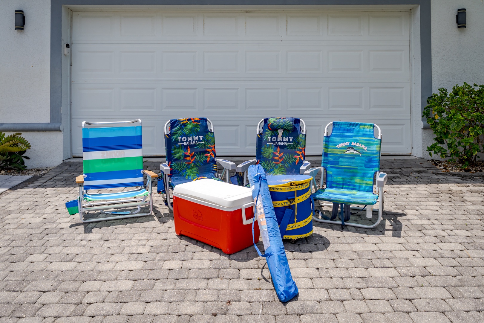 Beach-ready setup awaits: grab the cooler, chairs, and umbrella for your perfect day by the water, all prepared and waiting just steps from your door.