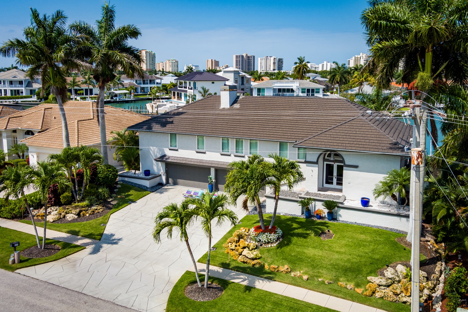 Waterfront rental property nestled in a lush tropical neighborhood with nearby city views and pristine landscaping.