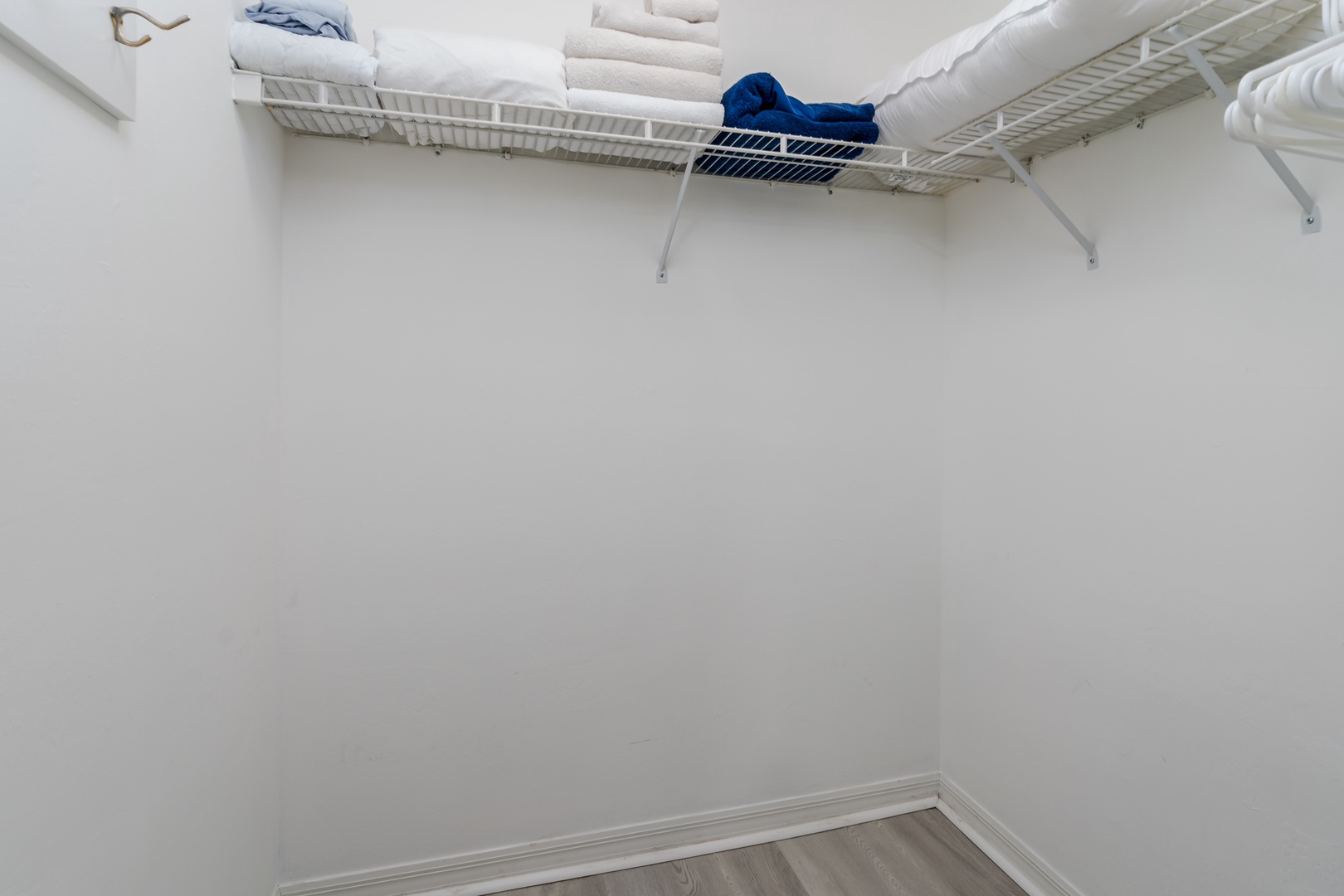 A spacious walk-in closet provides plenty of room for your wardrobe and belongings, with organized shelving already stocked with fresh linens and towels for your stay.