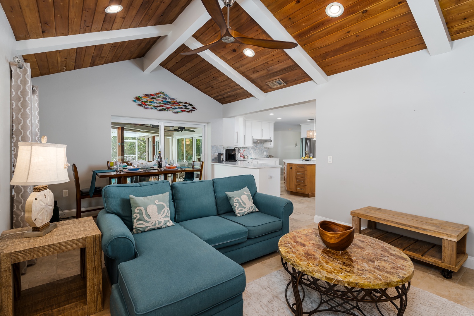 Sink into your spacious sectional beneath dramatic vaulted ceilings, where warm wood beams create a coastal cottage feel in your open living space.