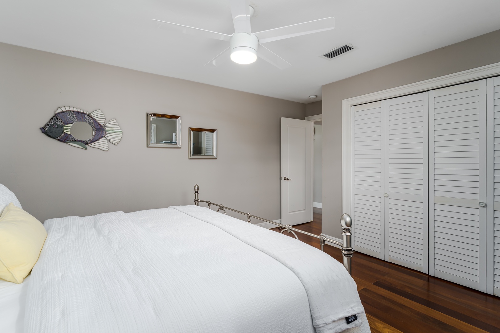 Drift off in your serene bedroom featuring a plush bed, hardwood floors, and ample closet space. A modern ceiling fan keeps you comfortable throughout your stay.