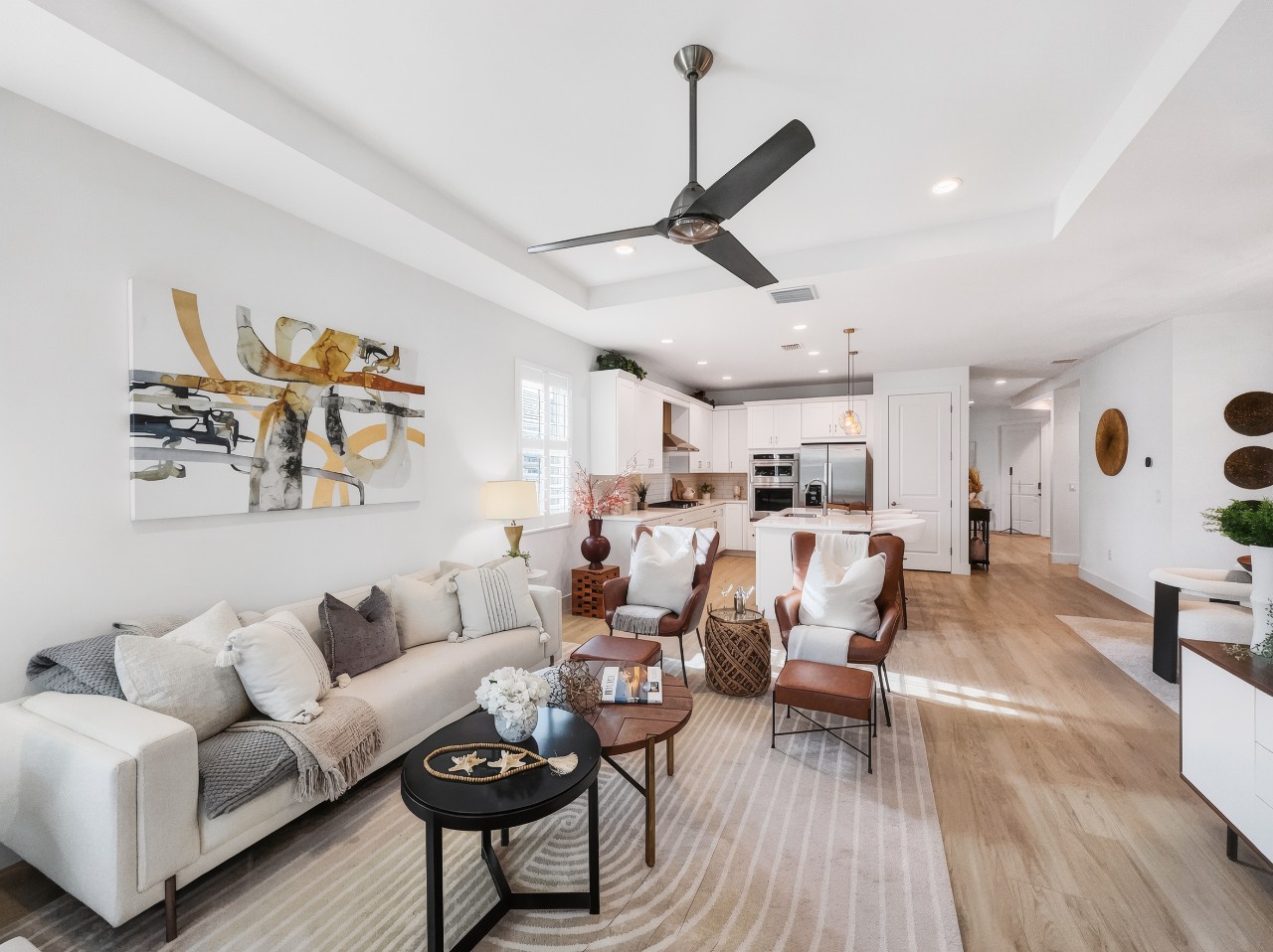 Bright, open-concept space with warm wood floors, soaring ceilings, and abundant natural light. Modern amenities including a sleek ceiling fan and fully equipped kitchen ensure a comfortable stay.