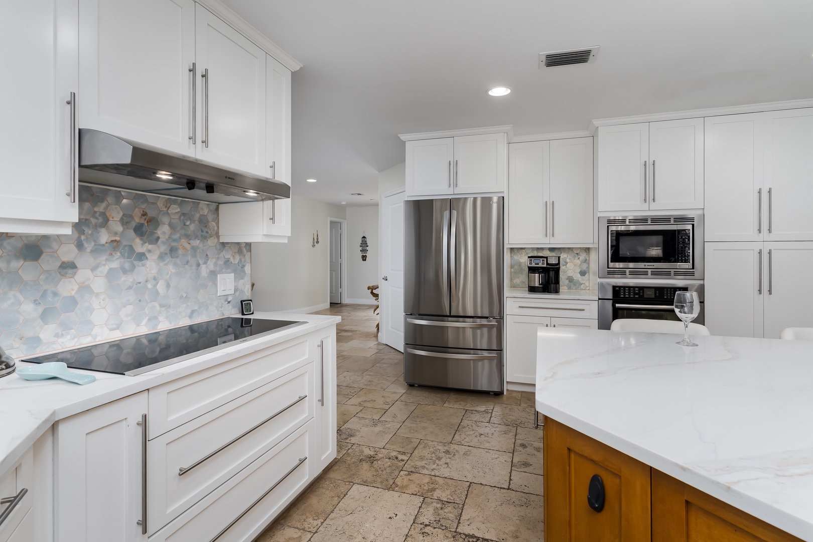 Cook with ease in your modern kitchen featuring sleek white cabinets, granite countertops, and premium stainless steel appliances.