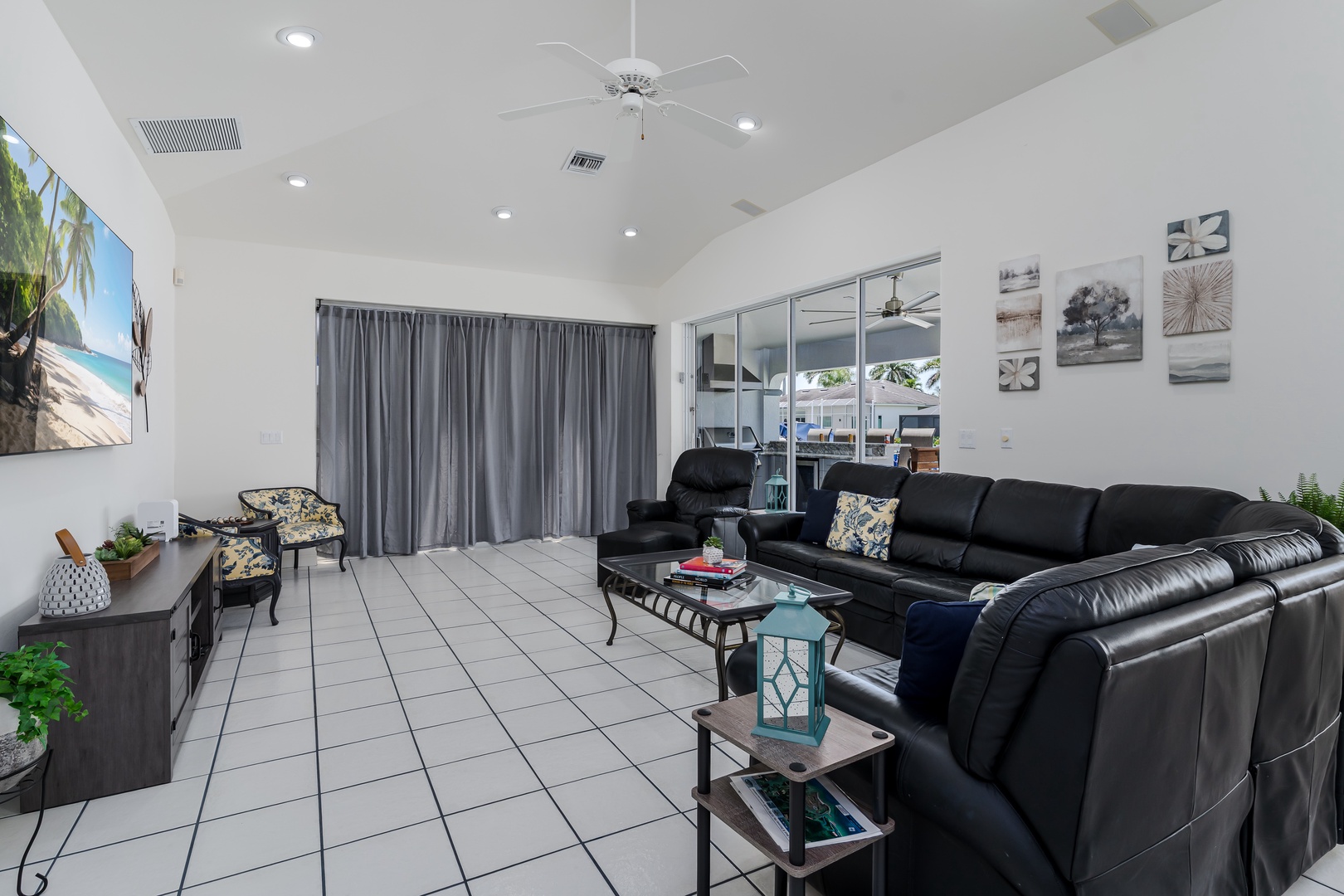 Relax in your spacious living room with vaulted ceilings, comfy leather seating, and a ceiling fan keeping you cool. Plenty of natural light and tasteful décor complete the welcoming space.