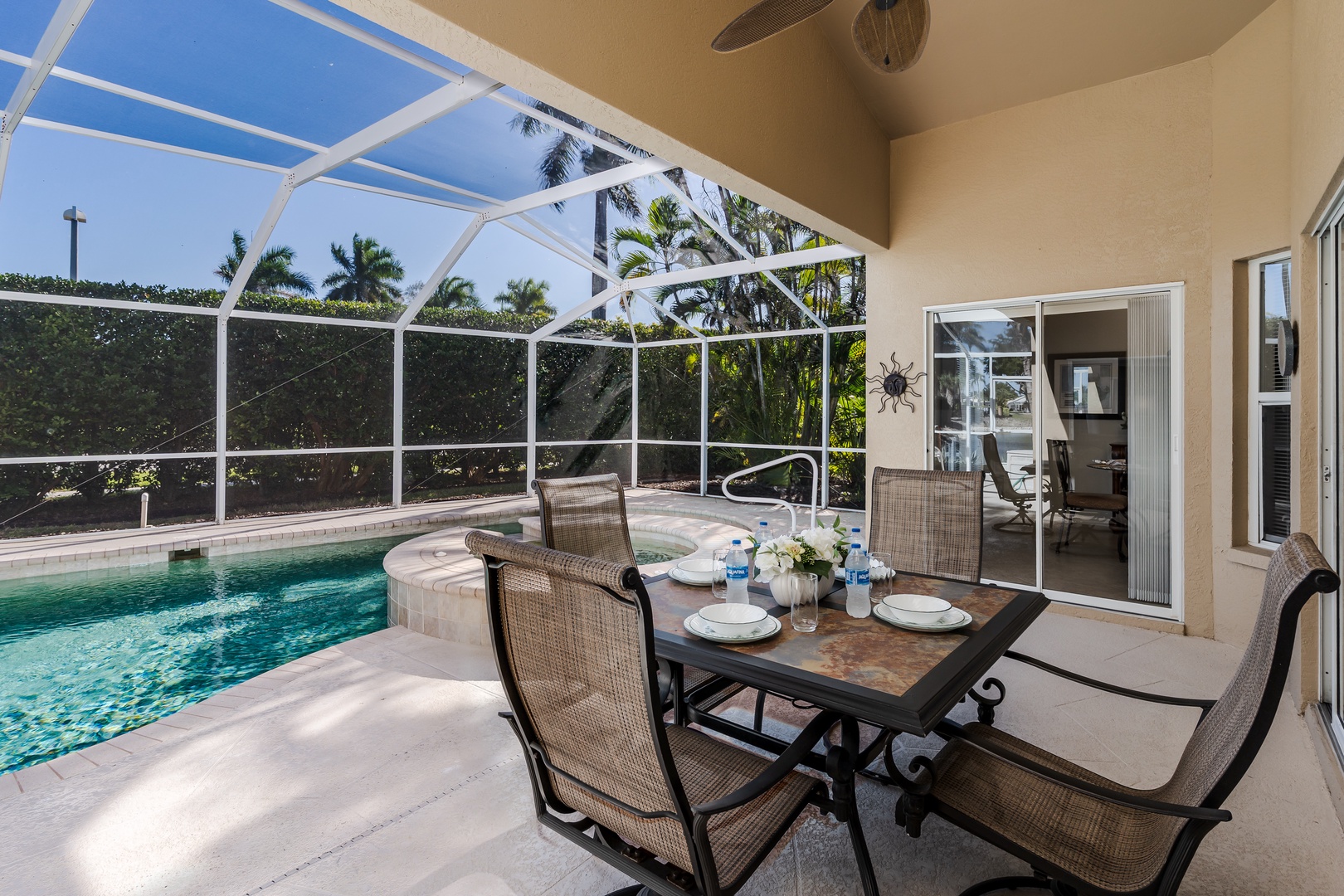 Your private screened pool and spa await, with dining space for memorable meals overlooking tropical palms and sparkling water.