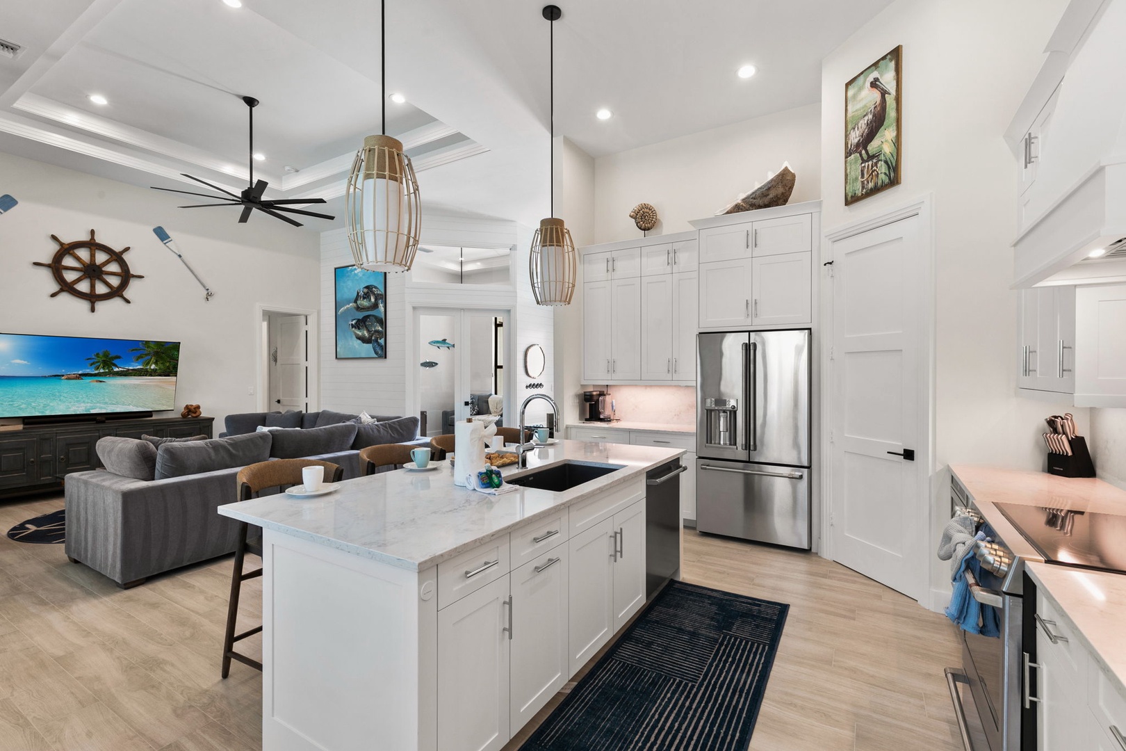 Bright, open-concept retreat with gleaming white cabinetry, sleek kitchen island, and stainless appliances. Coastal charm meets comfort in a space designed to feel like home.