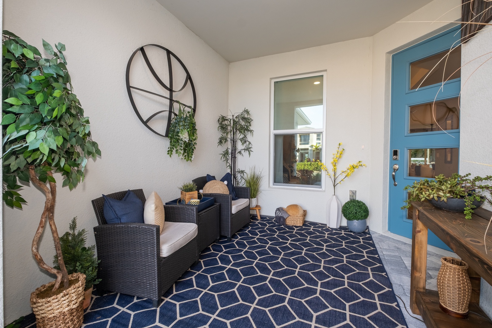 Unwind on your private covered patio with cozy wicker seating and lush greenery.