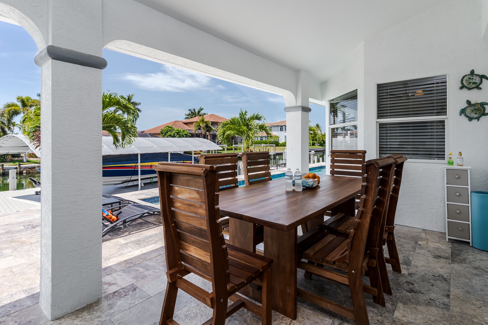 Gather around your private outdoor dining table for meals under the covered patio, with waterfront views and gentle tropical breezes setting the perfect scene for relaxation.