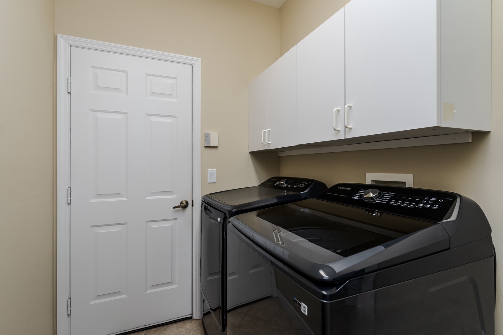 Your dedicated laundry room features modern washer and dryer with ample cabinet storage above for all your linens and essentials.