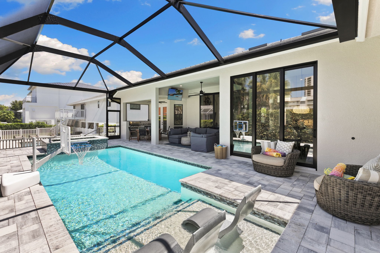 Dive into your private oasis under a screened lanai, where sparkling turquoise water, modern lounge seating, and seamless indoor-outdoor living create the ultimate Florida escape.
