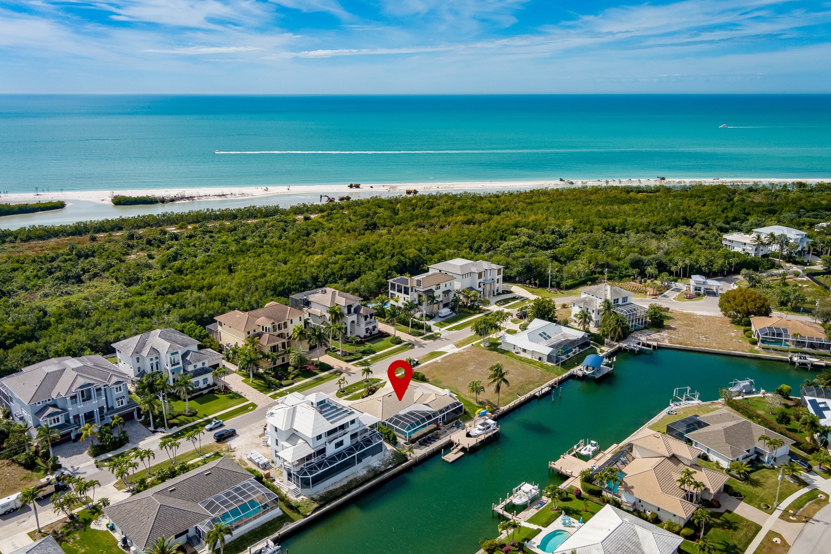 Waterfront community with pristine beaches and turquoise waters, featuring luxury homes along peaceful canals.