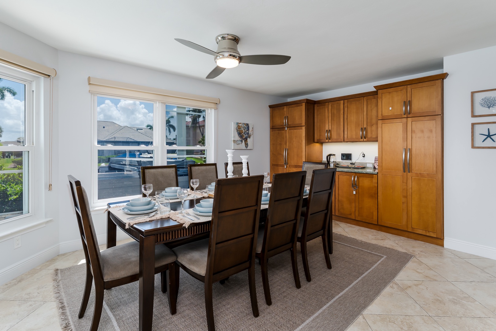 Gather around this elegant dining table for memorable meals, with rich wood cabinetry and natural light creating the perfect atmosphere.