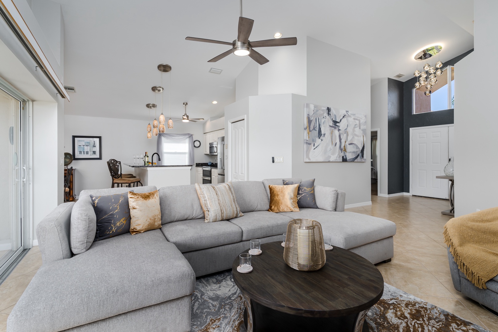 Sink into plush grey sectional seating in your bright, open living space with vaulted ceilings and modern touches.