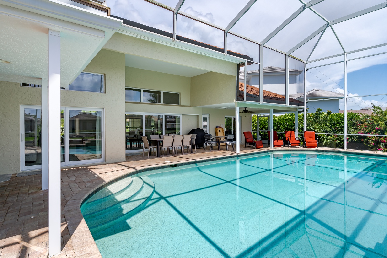 Dive into your private screened pool paradise, where crystal-clear waters meet vibrant loungers under Florida's endless blue skies.