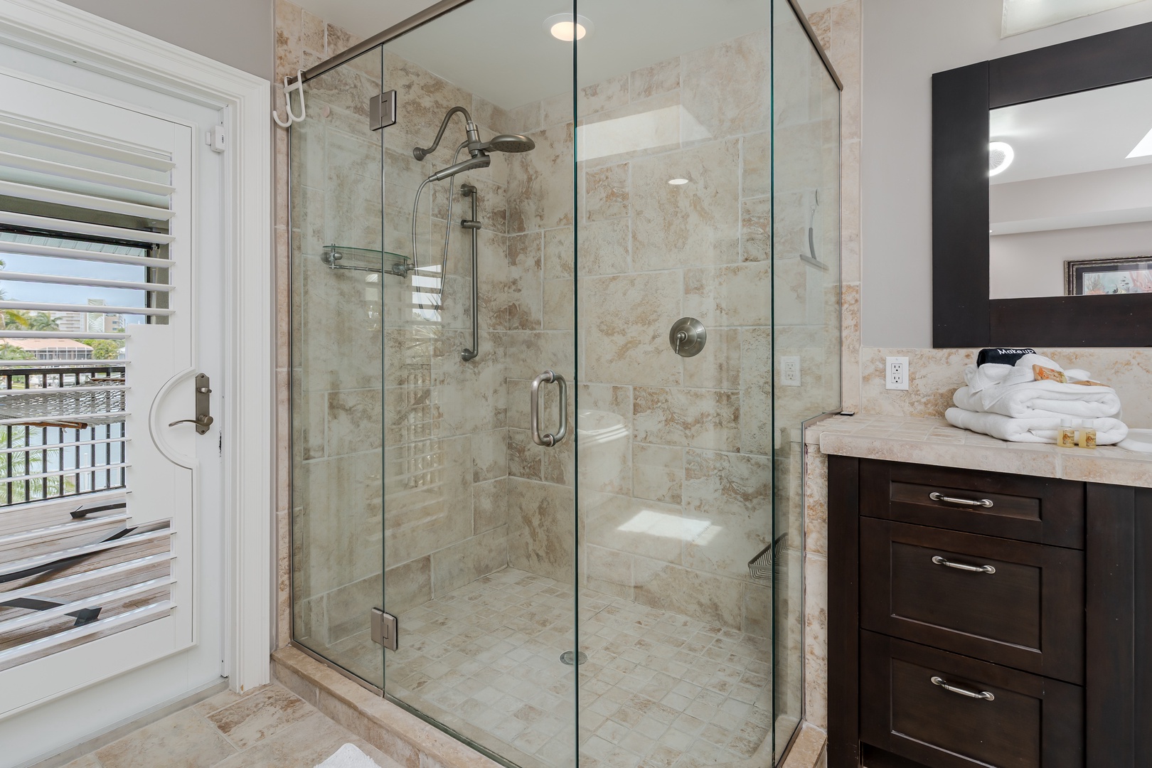 Refresh in your spacious glass-enclosed shower with natural light streaming in—plush towels and premium amenities await your arrival.