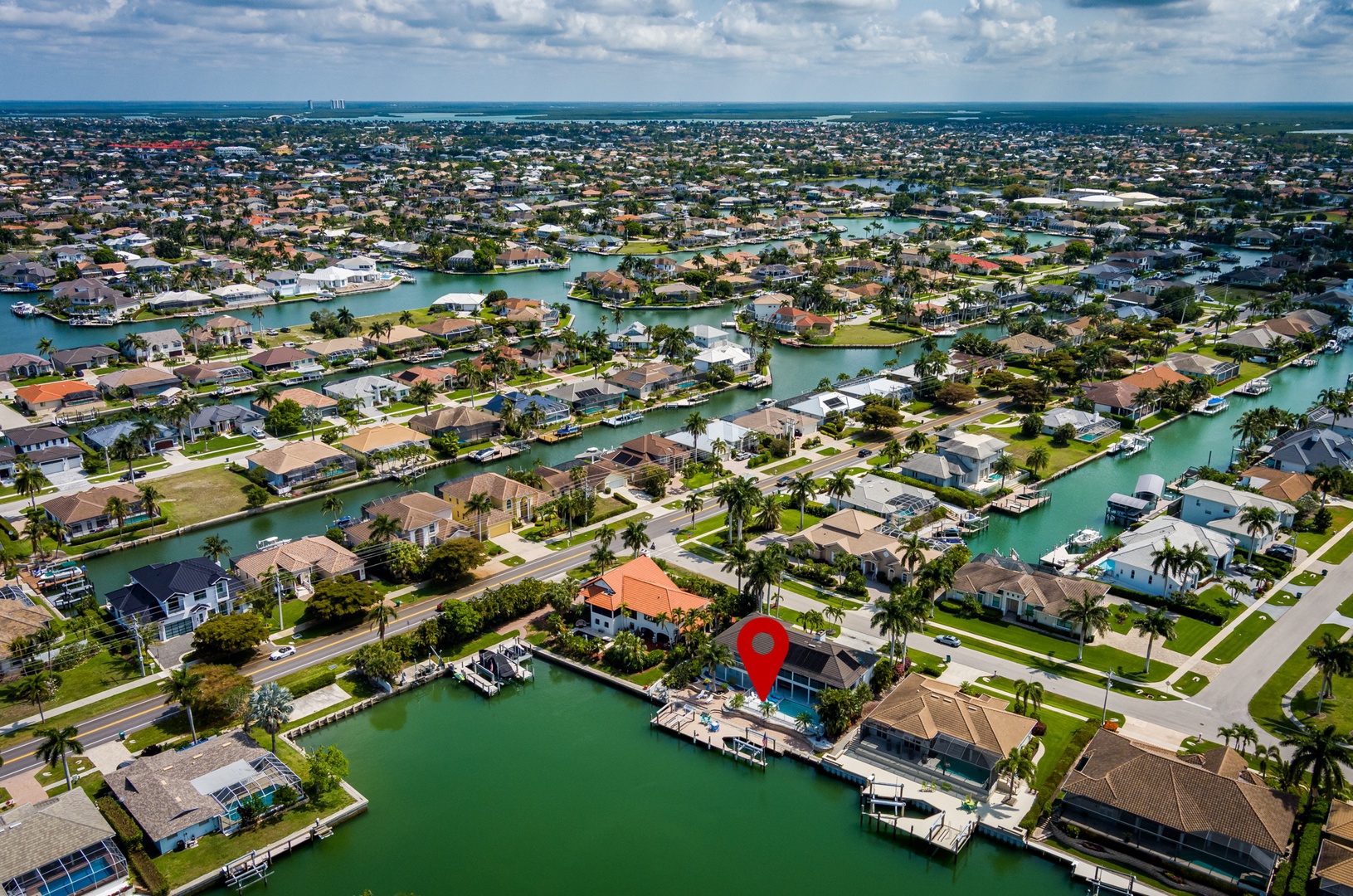 Aerial view of a waterfront community with canal access, palm-lined streets, and boat docks—perfect for exploring coastal Florida.