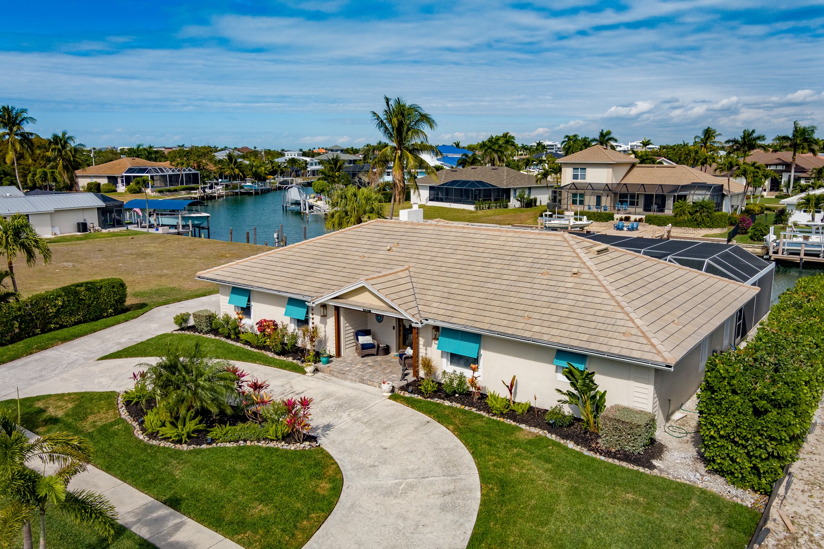 Waterfront paradise with tropical gardens and canal access in a serene neighborhood setting.