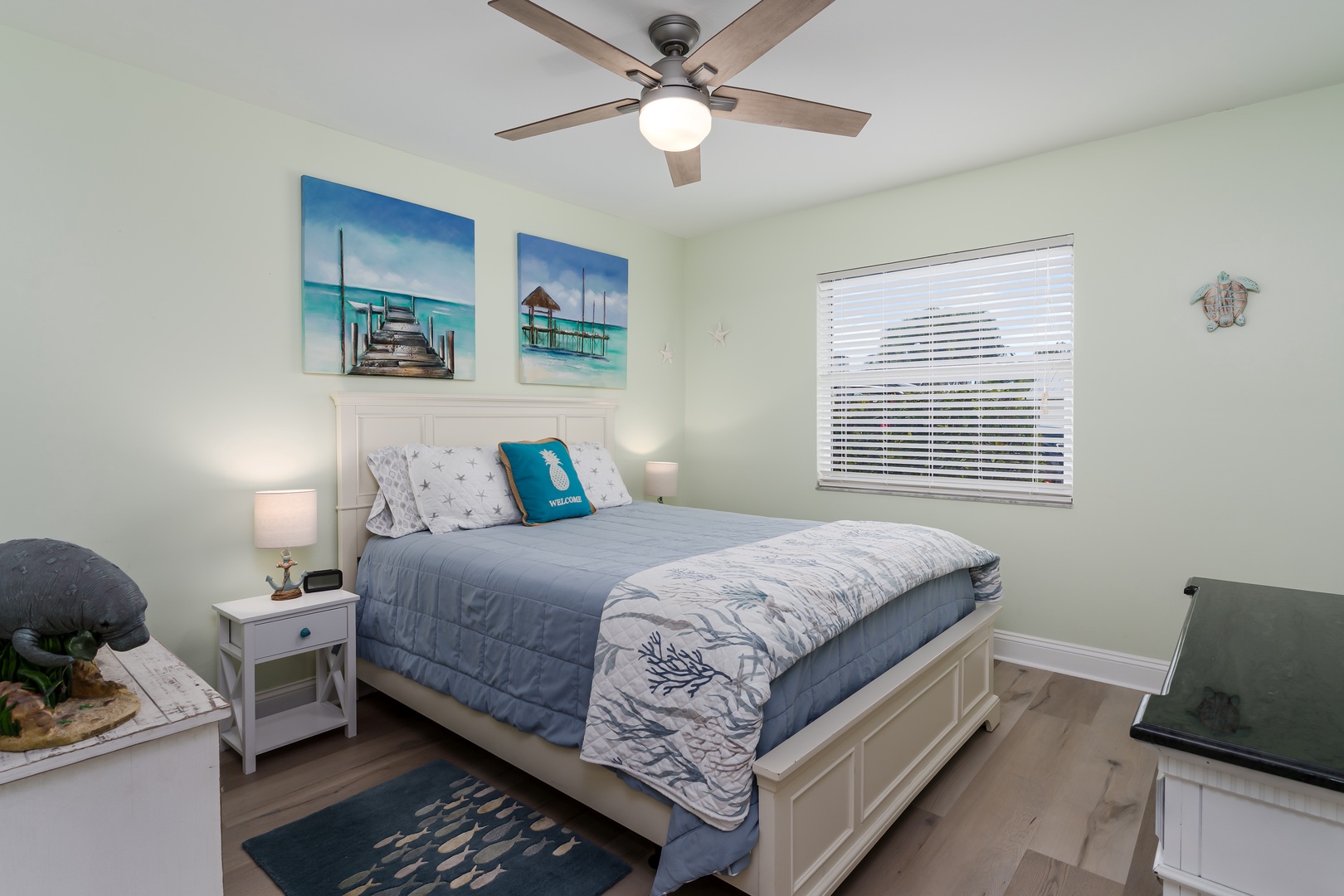 Drift off to sleep in this coastal-themed bedroom where ocean artwork and soothing blues create your personal seaside retreat.