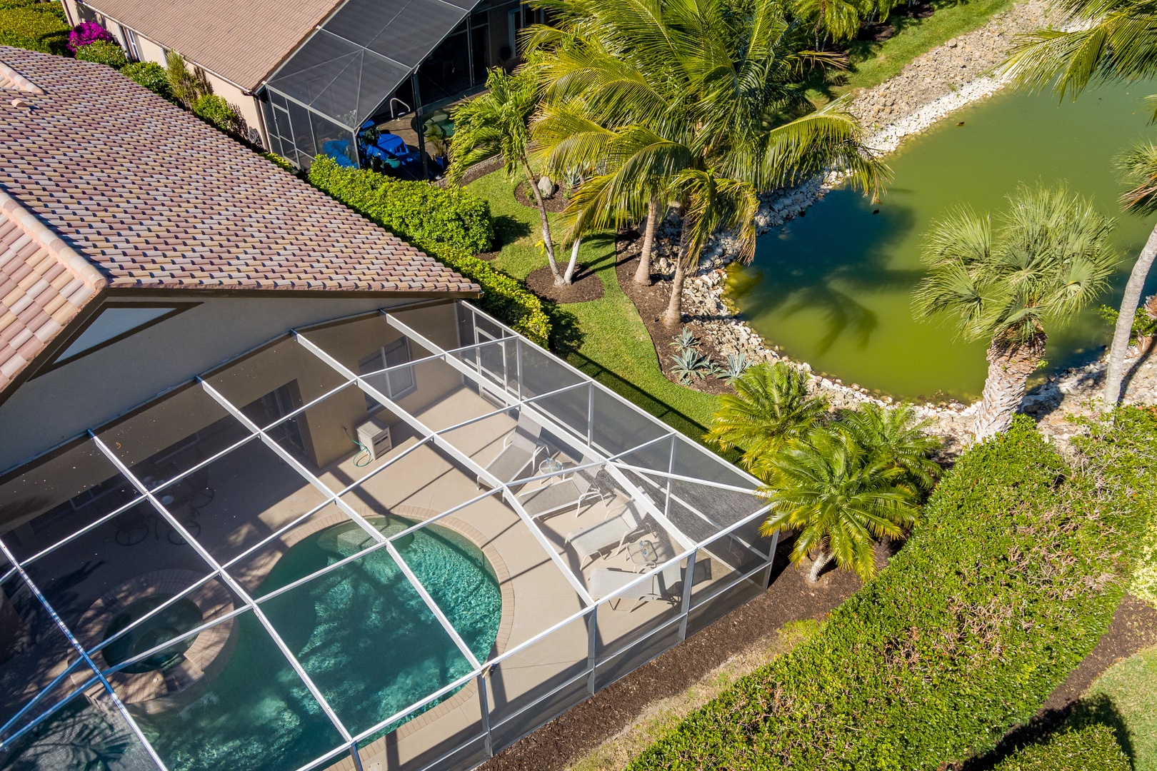 Waterfront property with screened pool area and tropical landscaping along peaceful canal waters.