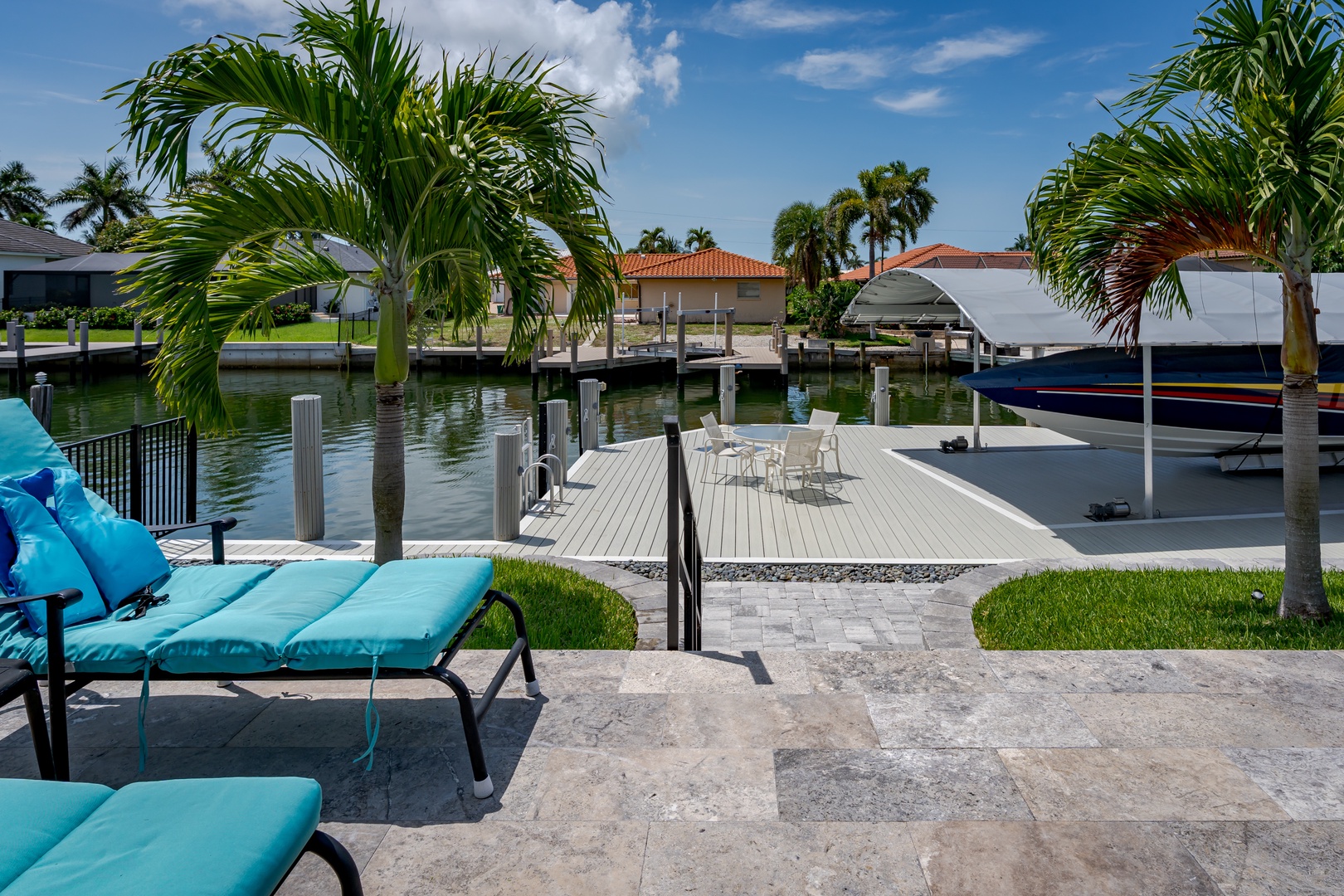 A private waterfront oasis featuring a spacious dock with boat access, framed by swaying palms. Picture yourself lounging on the patio as gentle waters invite relaxation.