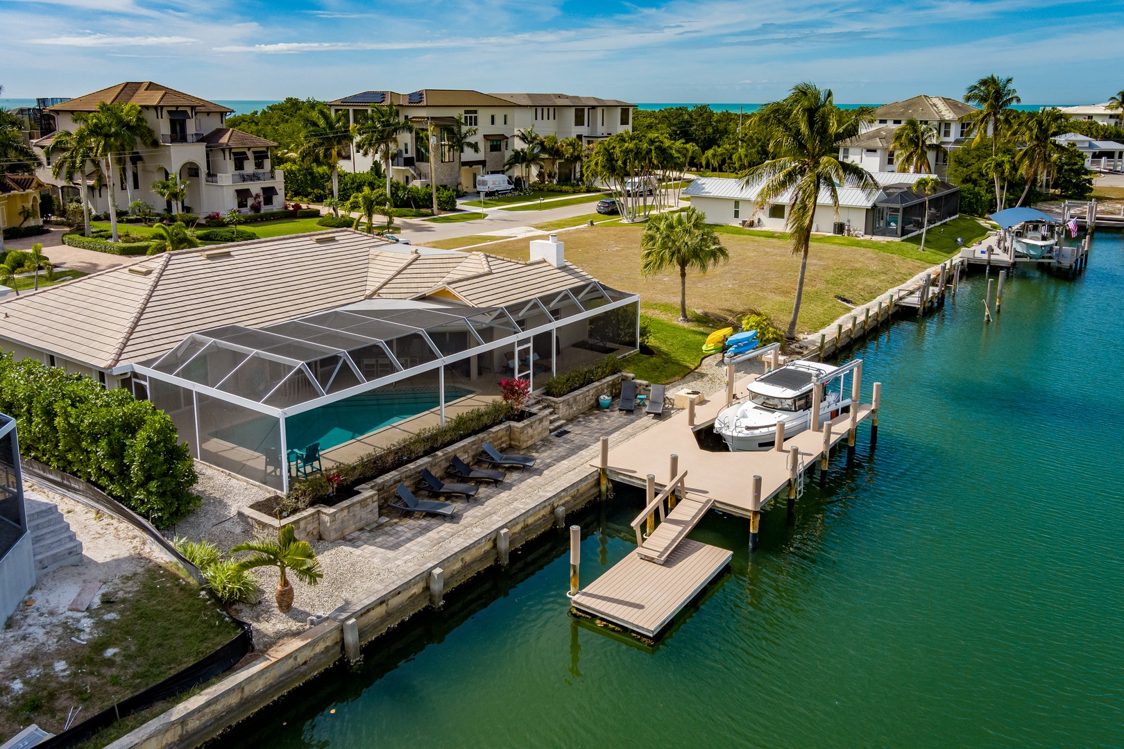 Waterfront vacation home with private dock and screened pool in tropical canal community.
