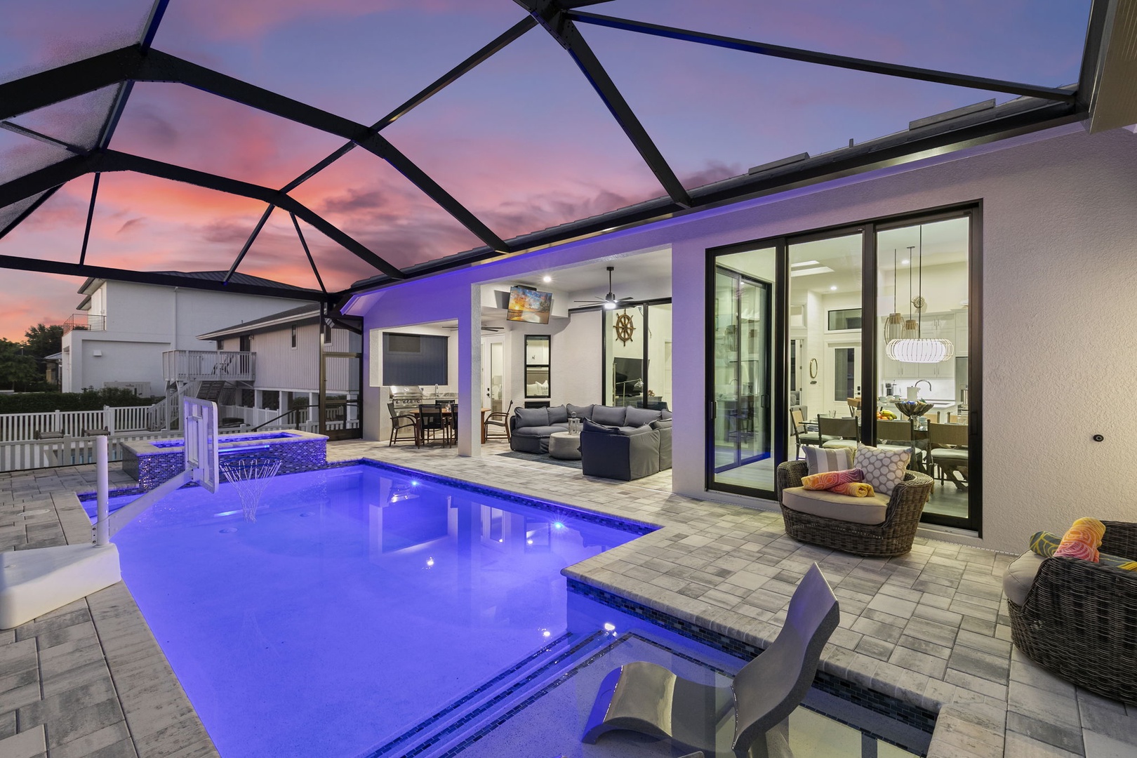 Your private pool glows under a screened lanai as sunset paints the sky, inviting you to unwind in this beautifully lit Florida-style retreat.