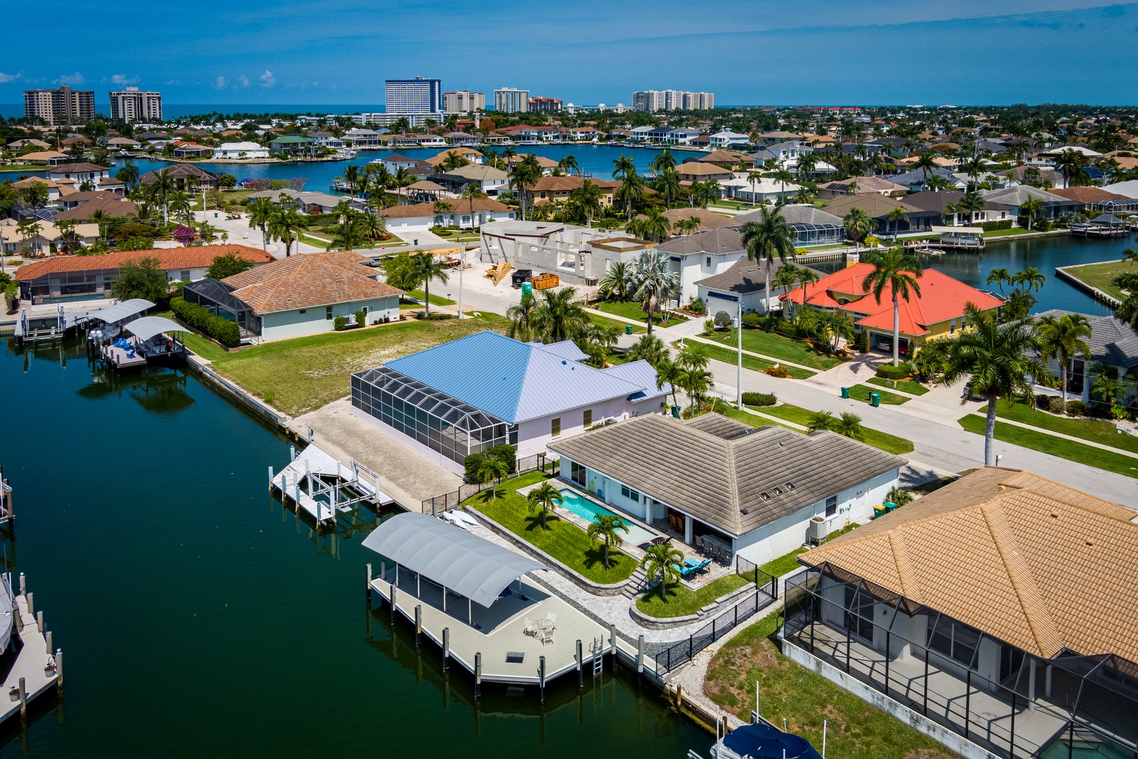 Aerial view of a waterfront neighborhood showcasing canal-side homes with private boat docks and tropical landscaping along a scenic Florida coastline.