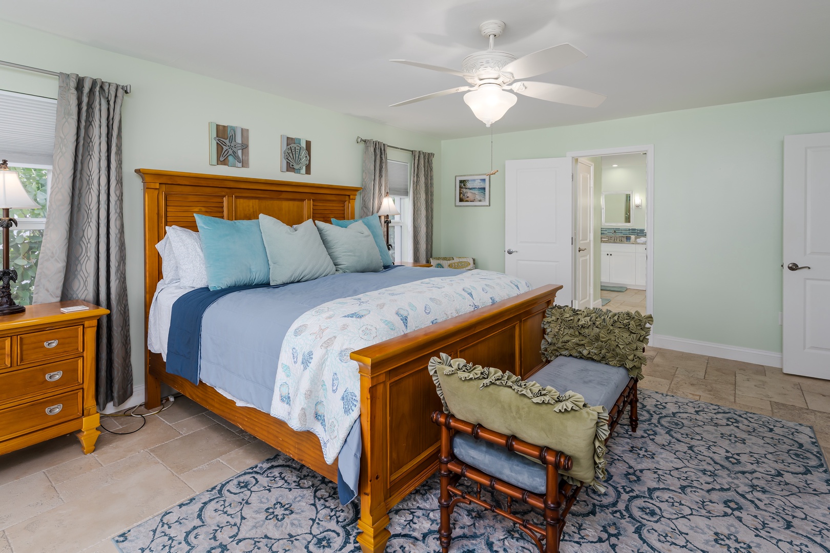 Drift off in your serene bedroom with coastal blues and warm wood furnishings, complete with ceiling fan and private bath access.