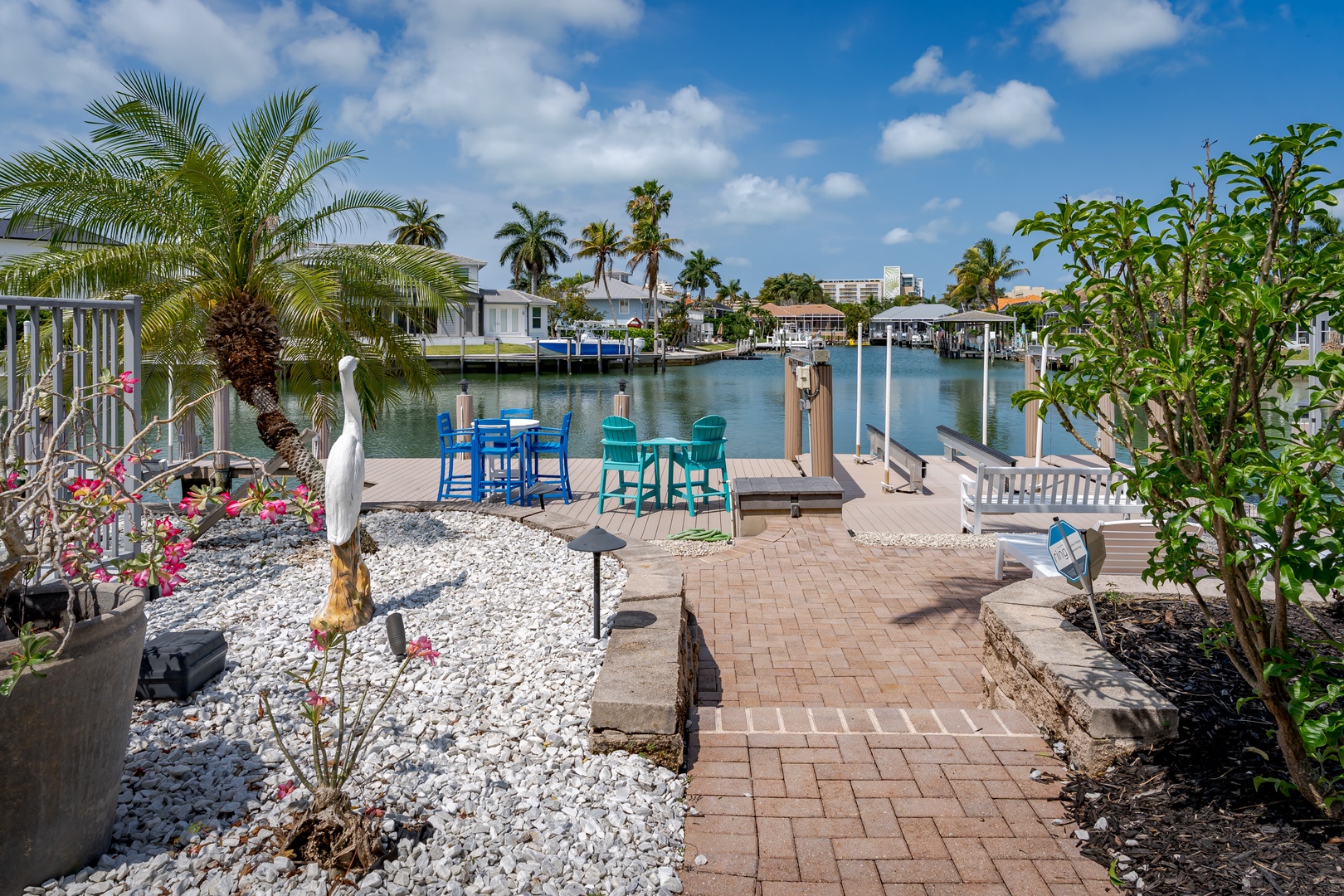 A waterfront oasis with private dock access where colorful seating invites leisurely afternoons overlooking the calm canal and swaying palms.