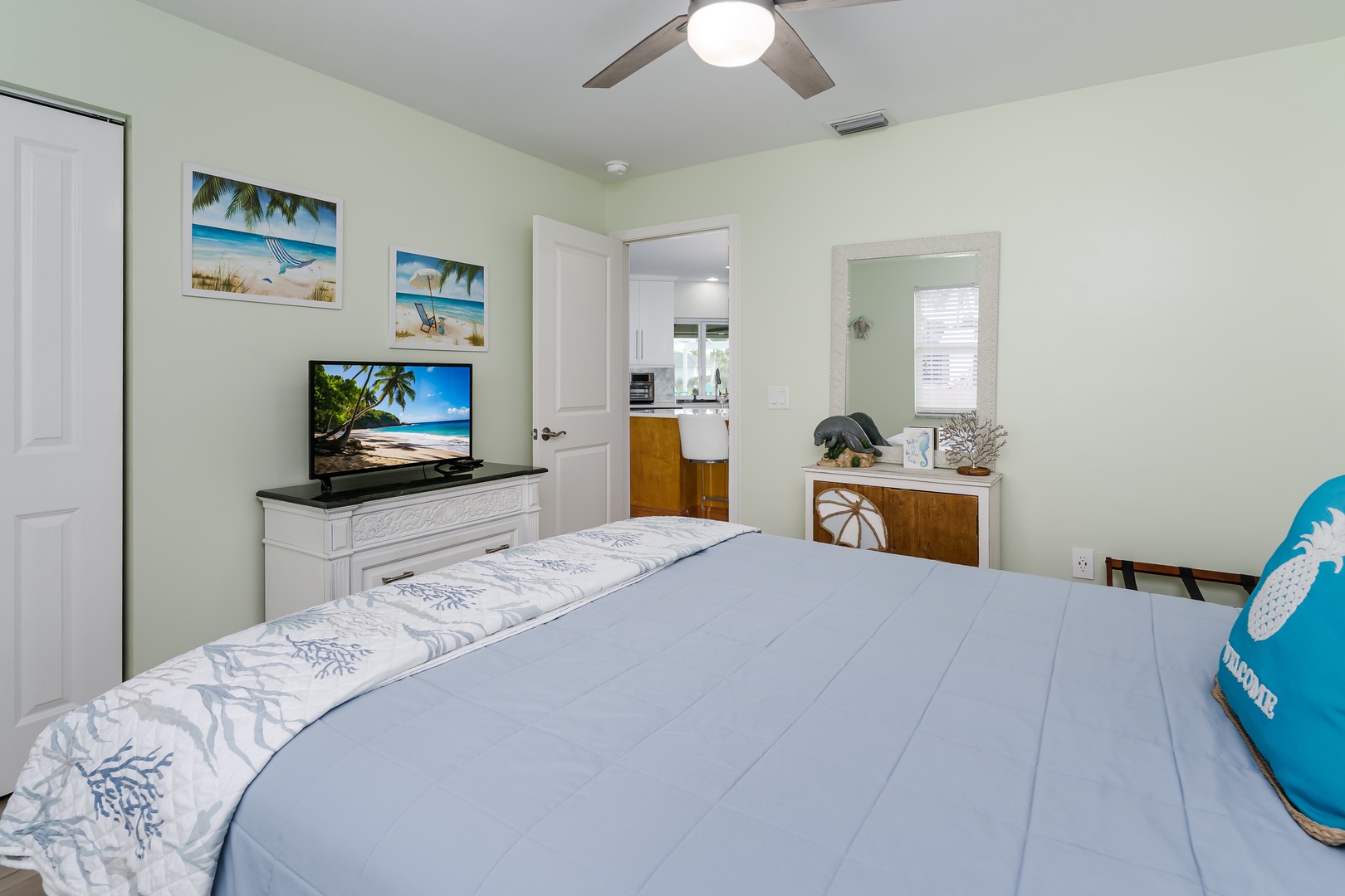Drift off in your cozy bedroom with tropical artwork, flat-screen TV, and ceiling fan keeping you comfortable.