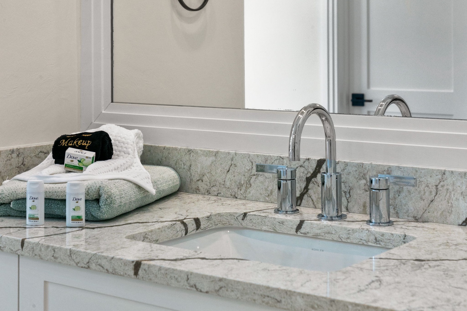 Refresh in your elegant bathroom with natural stone countertops, a modern faucet, and plush towels waiting just for you.